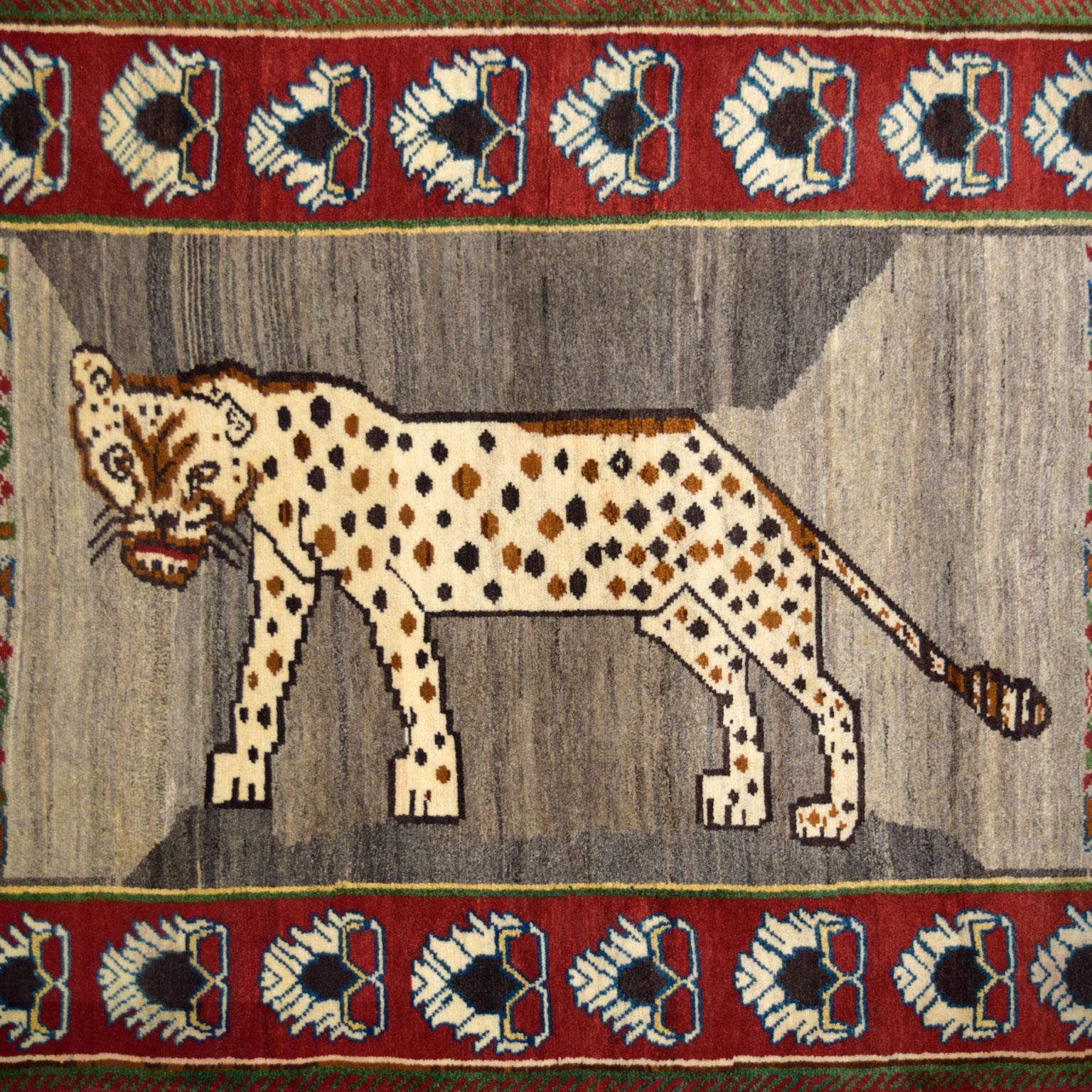 Hand-knotted in red, cream, grey, brown, green, blue, and gold handspun wool, this Persian Qashqai carpet measures 3’8” x 5’11” and features a distinctive prowling leopard design. Plush, functional, and resilient in quality, the hand-knotted weave