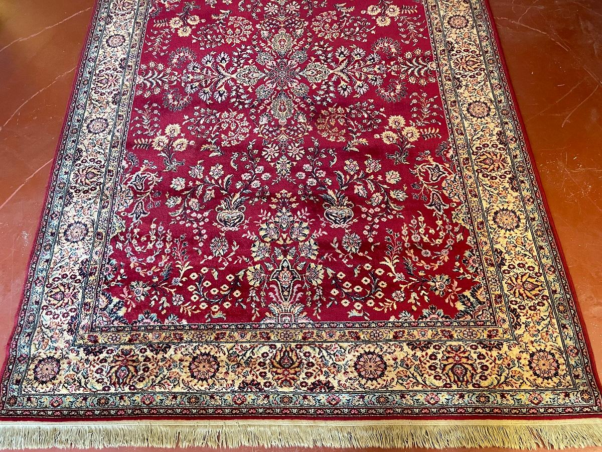 Hand knotted Persian rug measuring 2M13 by 2M02 with red decoration.
  