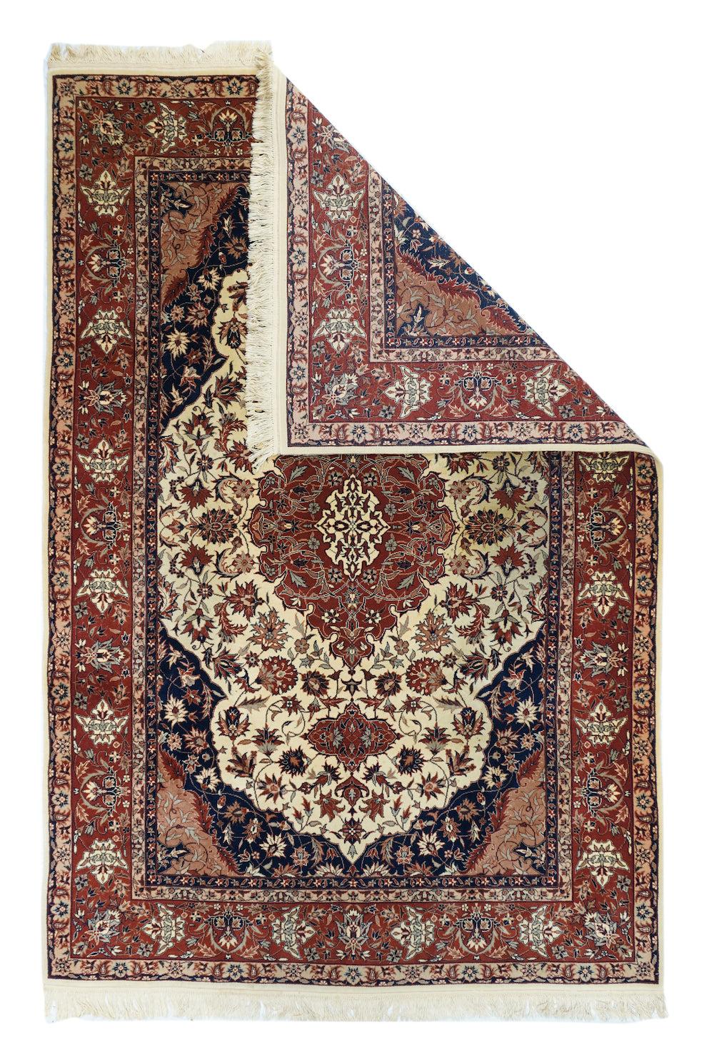 Persian Rug 6'0'' x 9'0''. Another mystery rug, with a cream field filled with a variety of mobile palmettes, hosting a flame-edged layered medallion, with barbed cartouche pendants. Near black corners with half palmette pendants. Red border with