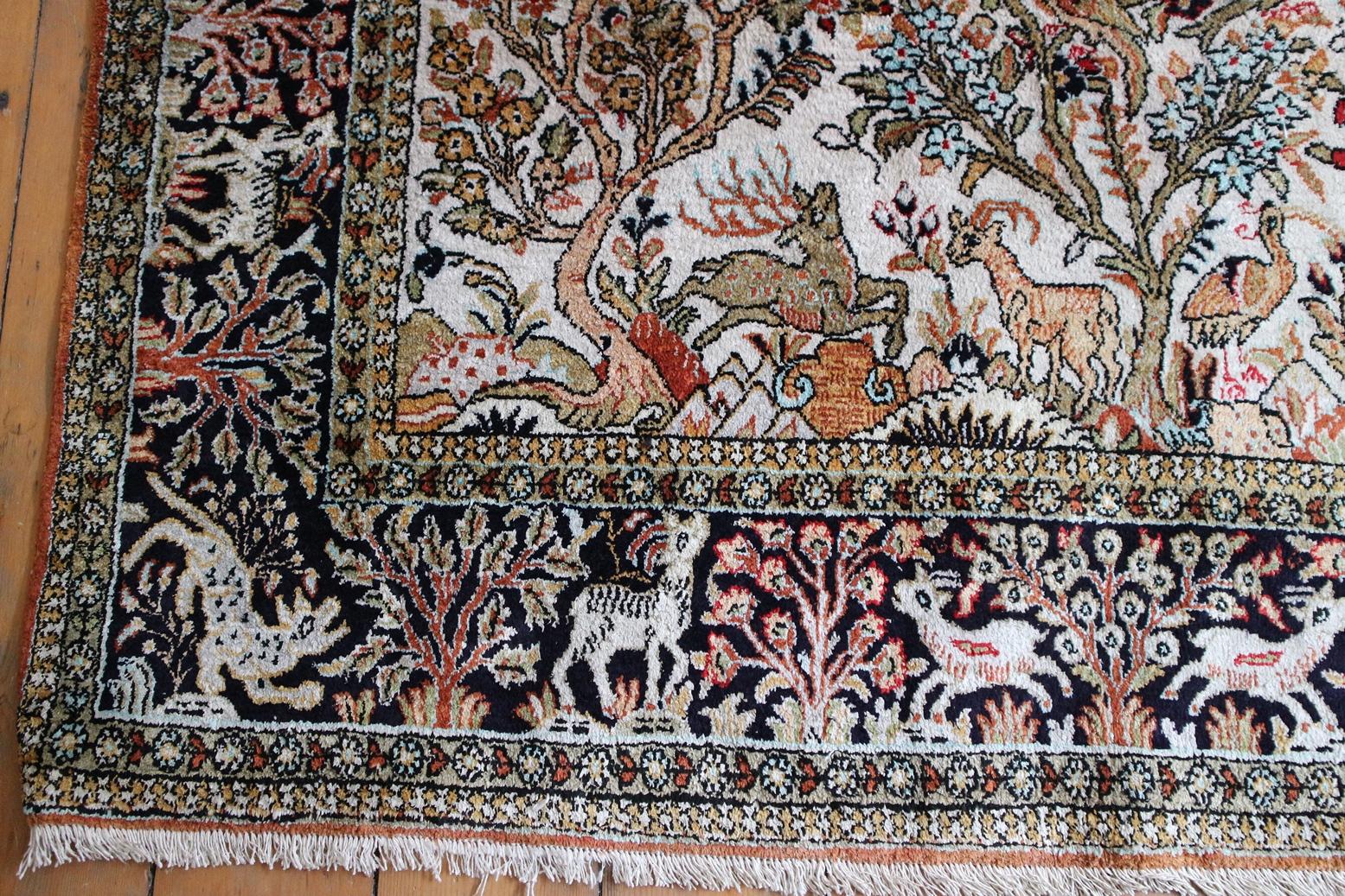 This beautiful silk rug is delicacy woven with the famous Persian pattern, tree of life, by artistic weavers from Qom city. the border is dark and background crème color full of blooms, flowers and animals. Tree of life is representation of Paradise