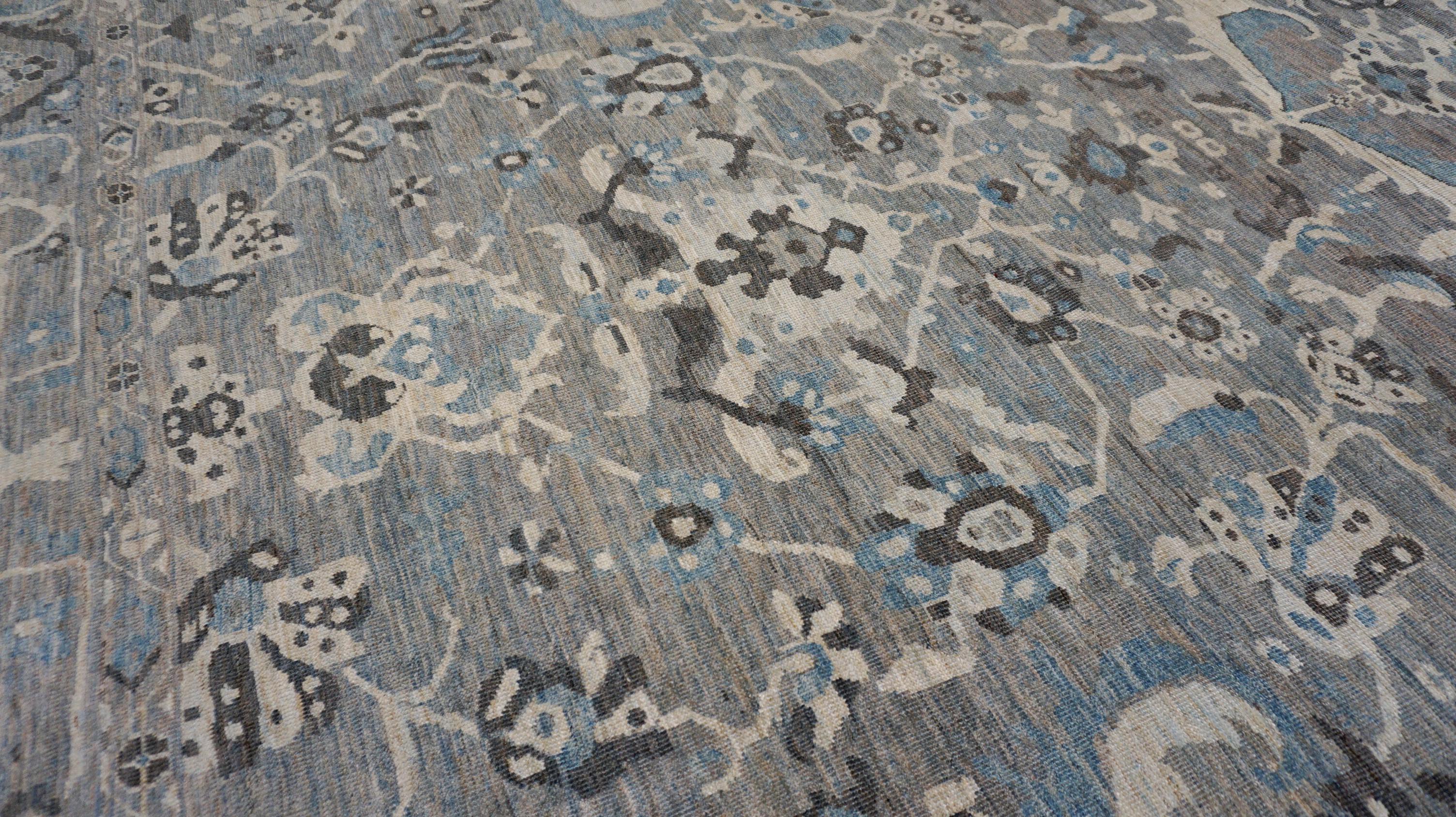 This exquisite hand-knotted wool rug showcases the elegance and artistry of traditional weaving, highlighted by a sophisticated palette of soft blues, greys, white, and charcoal tones. Expertly crafted by skilled artisans, the rug features an