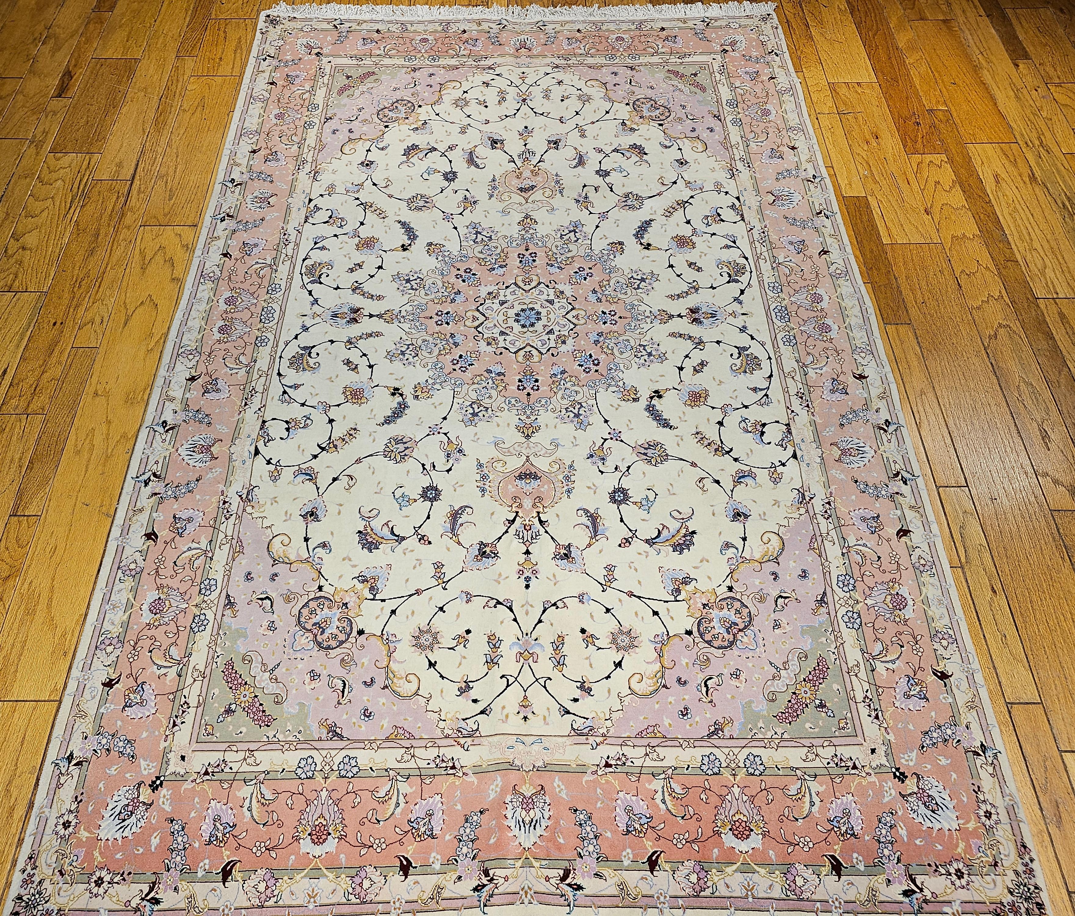 Fine Persian Tabriz in a floral pattern in a cream color background and a pale pink border.  It is artistically woven with a wool pile on a cotton foundation with silk highlighting the designs in a fine workshop in the city of Tabriz in NW Persia. 