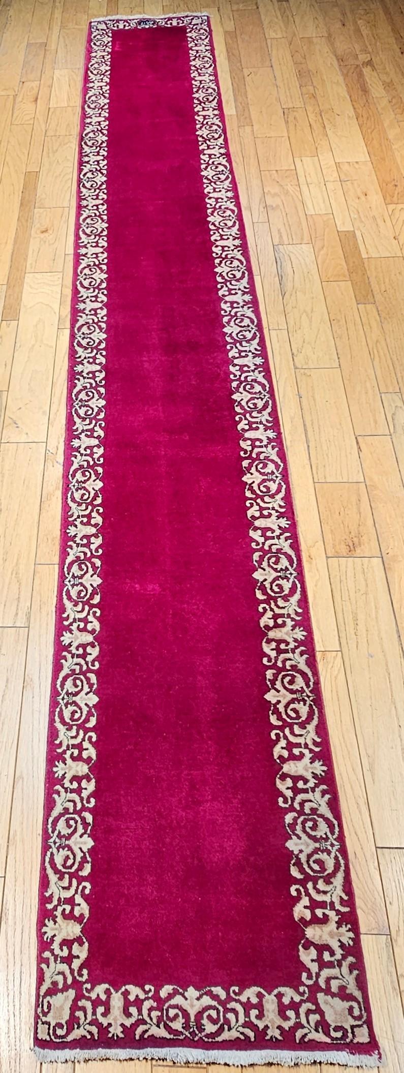 Simple and Elegant!  That is the best way to describe this beautiful Persian Tabriz runner from the mid 1900s.  The Tabriz runner  in an open pattern set on a rich crimson color background with a beautiful scrolling cream color.  The rug has a wool
