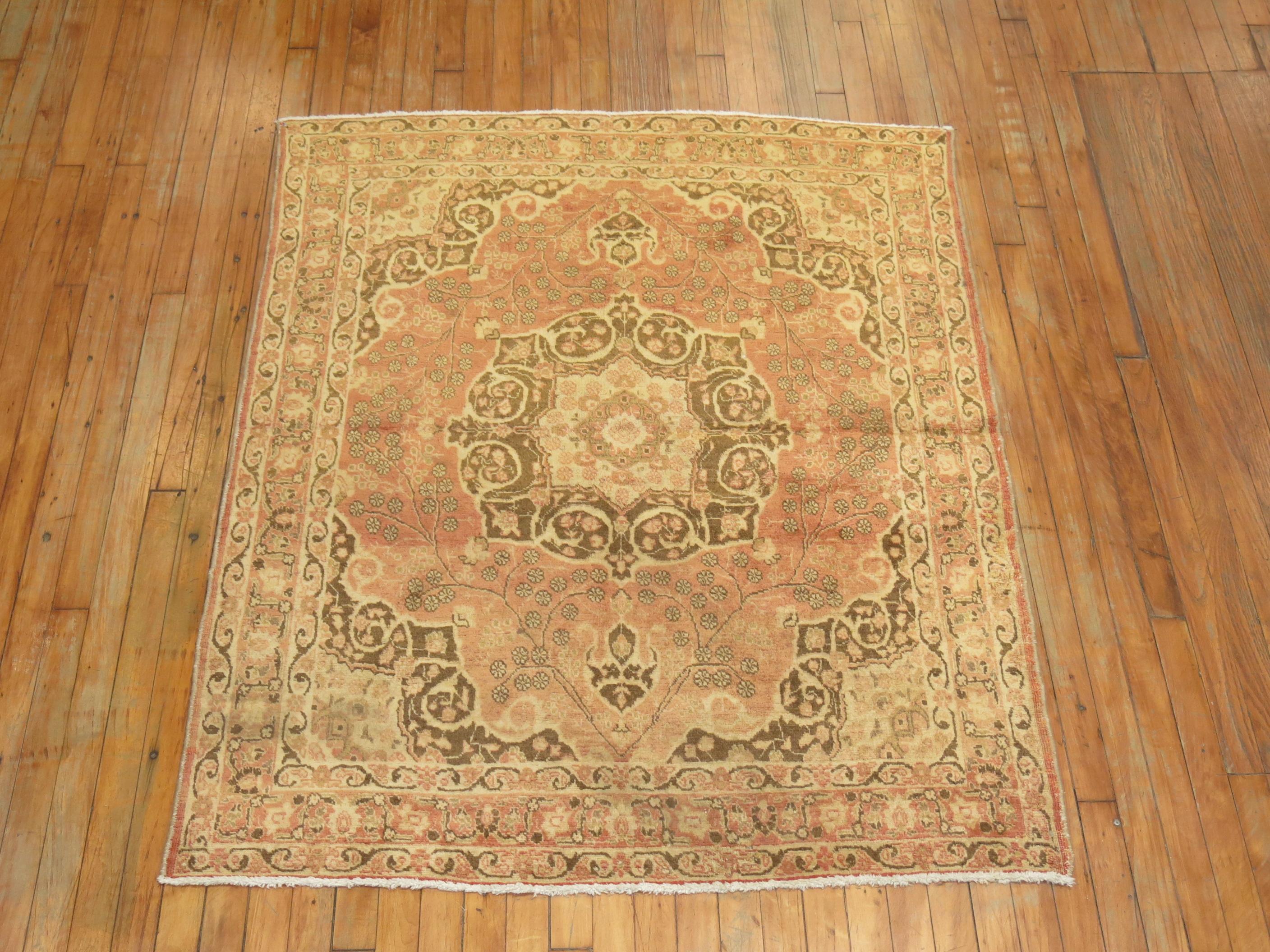 An authentic one of a kind Antique Persian Tabriz rug featuring Classic medallion and border in brown and salmon.