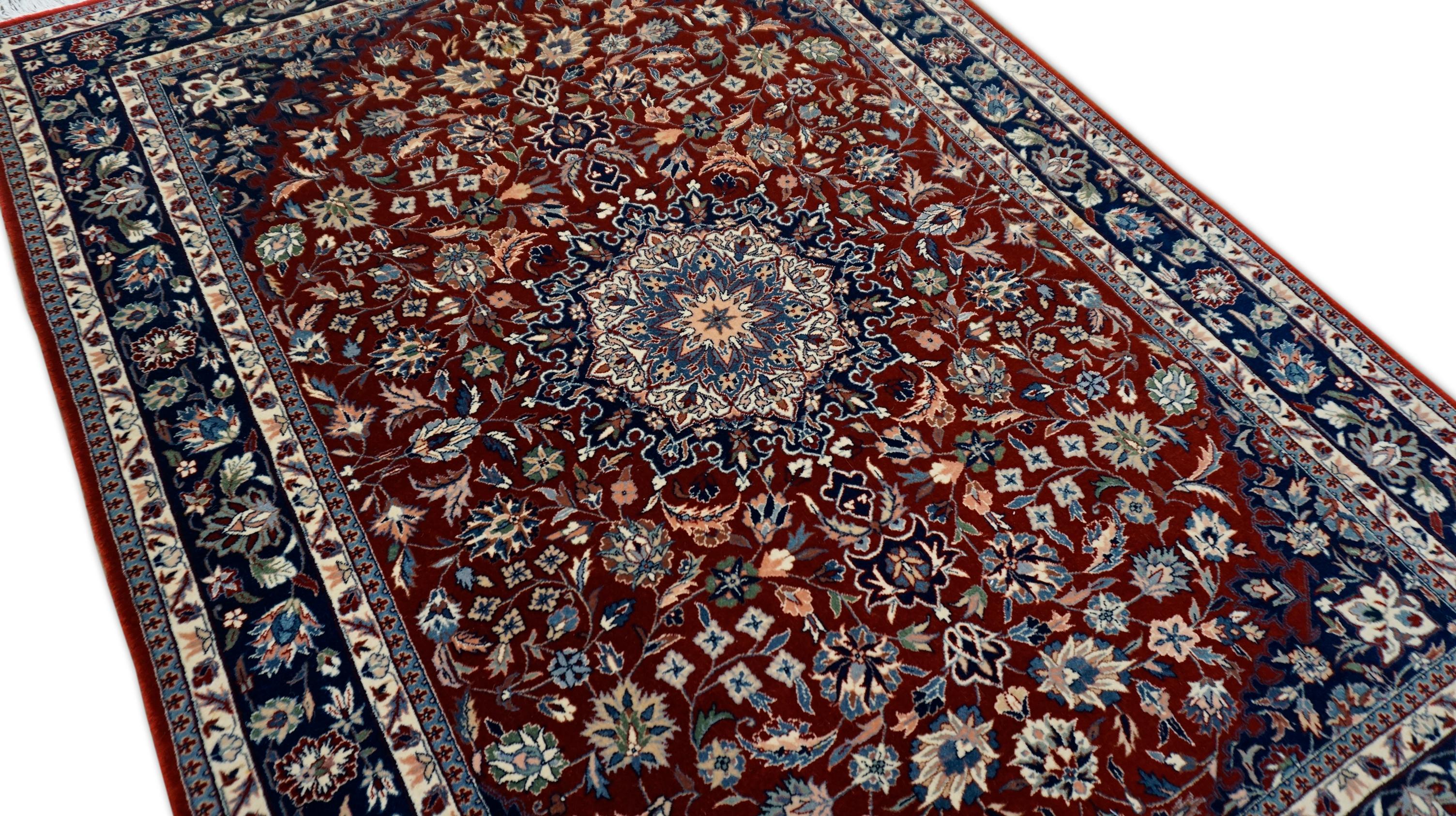 Questo squisito tappeto in lana annodato a mano riproduce magnificamente l'intricata tradizione dei tappeti persiani Kashan. Il tappeto presenta un grande medaglione centrale su un ricco campo rosso cremisi, circondato da eleganti motivi floreali e