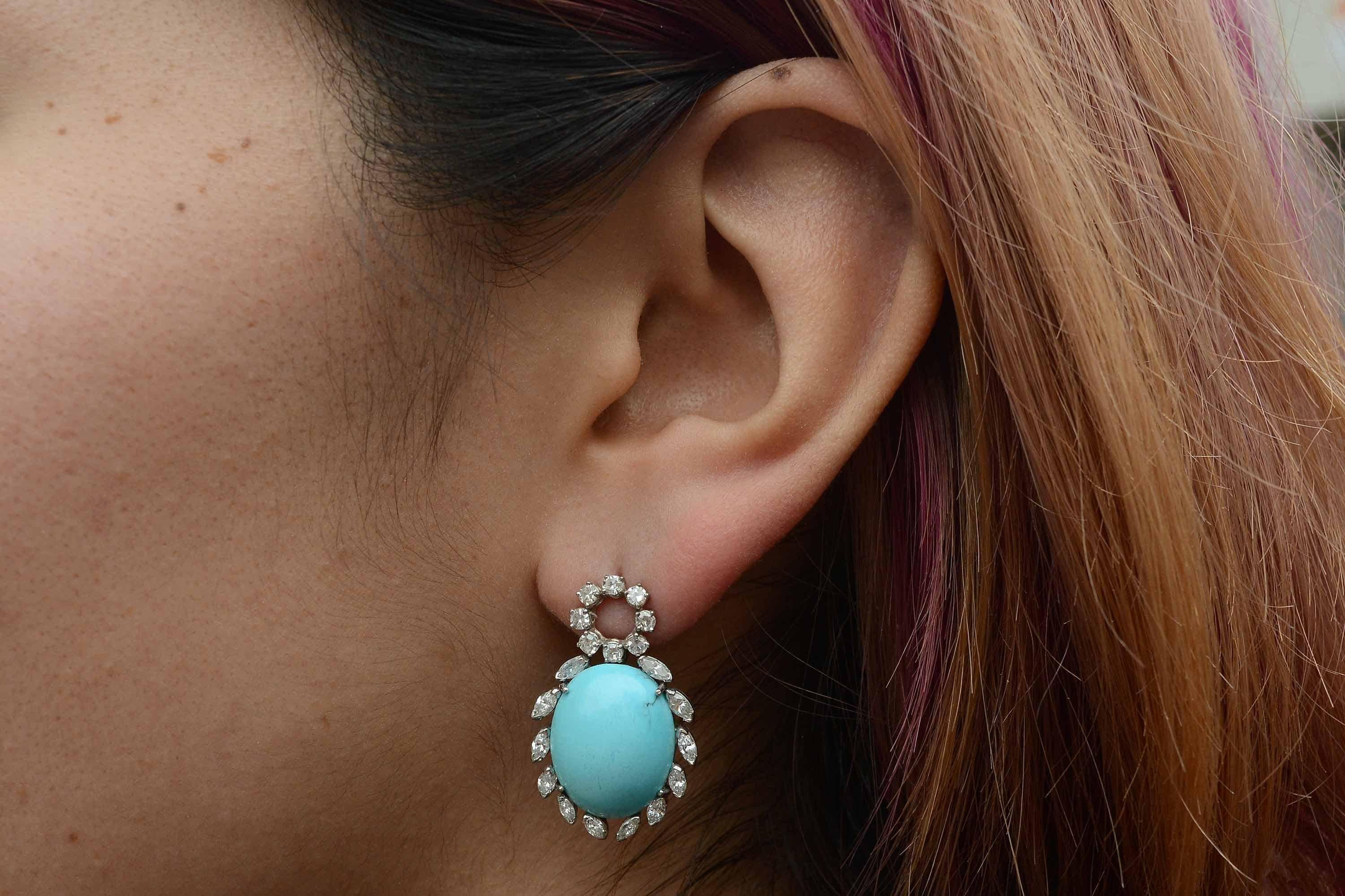 With a captivating, refreshing robin's egg blue, these Persian turquoise cocktail earrings command attention. Of significant size, surrounded with a halo of 20 dazzling marquise and round diamonds totaling 2.16 Ct. 1970s Vintage, they dangle from a