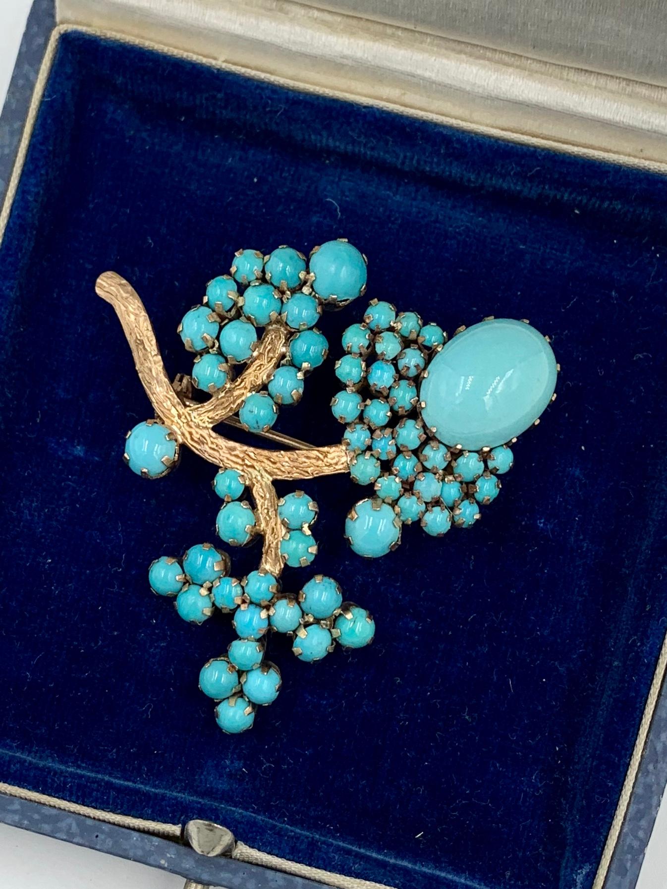 A flower motif brooch with gorgeous Persian Turquoise of great beauty.  The abundance of Persian Turquoise Cabochons are of the highest quality with superb color uniformity.  The brooch is beautifully made with the myriad of sizes of round and oval