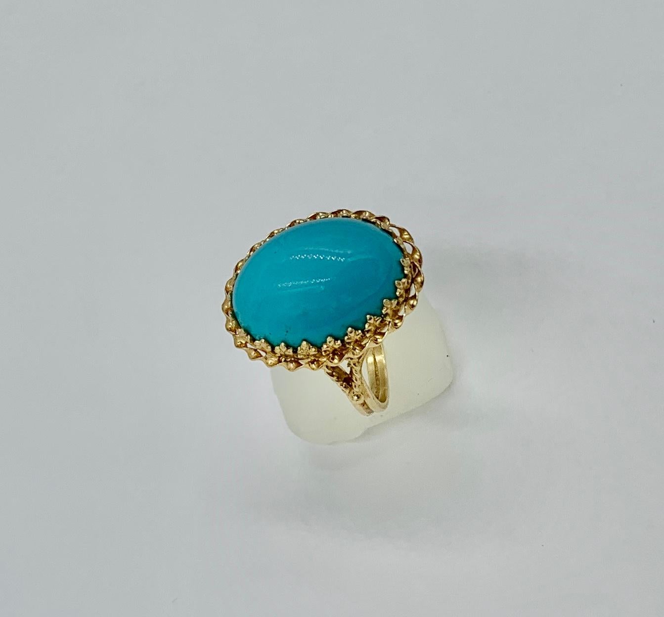 A gorgeous Persian Turquoise Ring with a stunning 14 Carat 18mm Turquoise Cabochon.  The Turquoise is set in a lovely fleur de lit border setting in 14 Karat Yellow Gold.  The vivid oval Turquoise cabochon is of such lovely color and has great