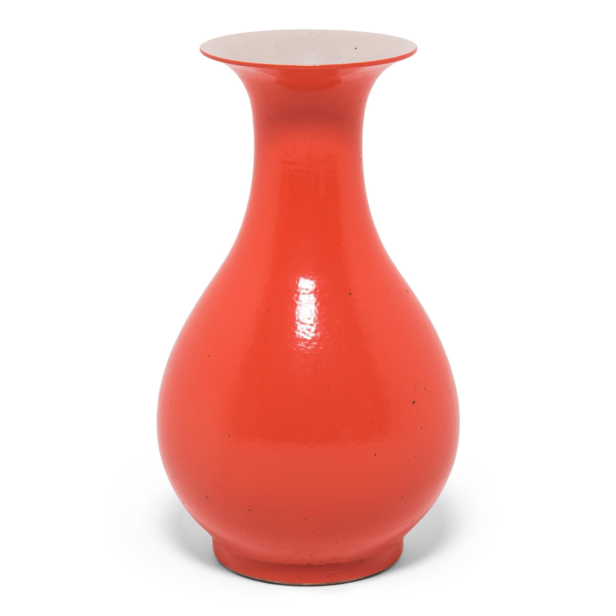 Le monochrome saisissant de ce vase s'inspire d'une longue tradition chinoise de céramiques émaillées d'une seule et unique couleur. La forme gracieusement incurvée de ce vase en porcelaine est animée par une glaçure orange vibrante inspirée du
