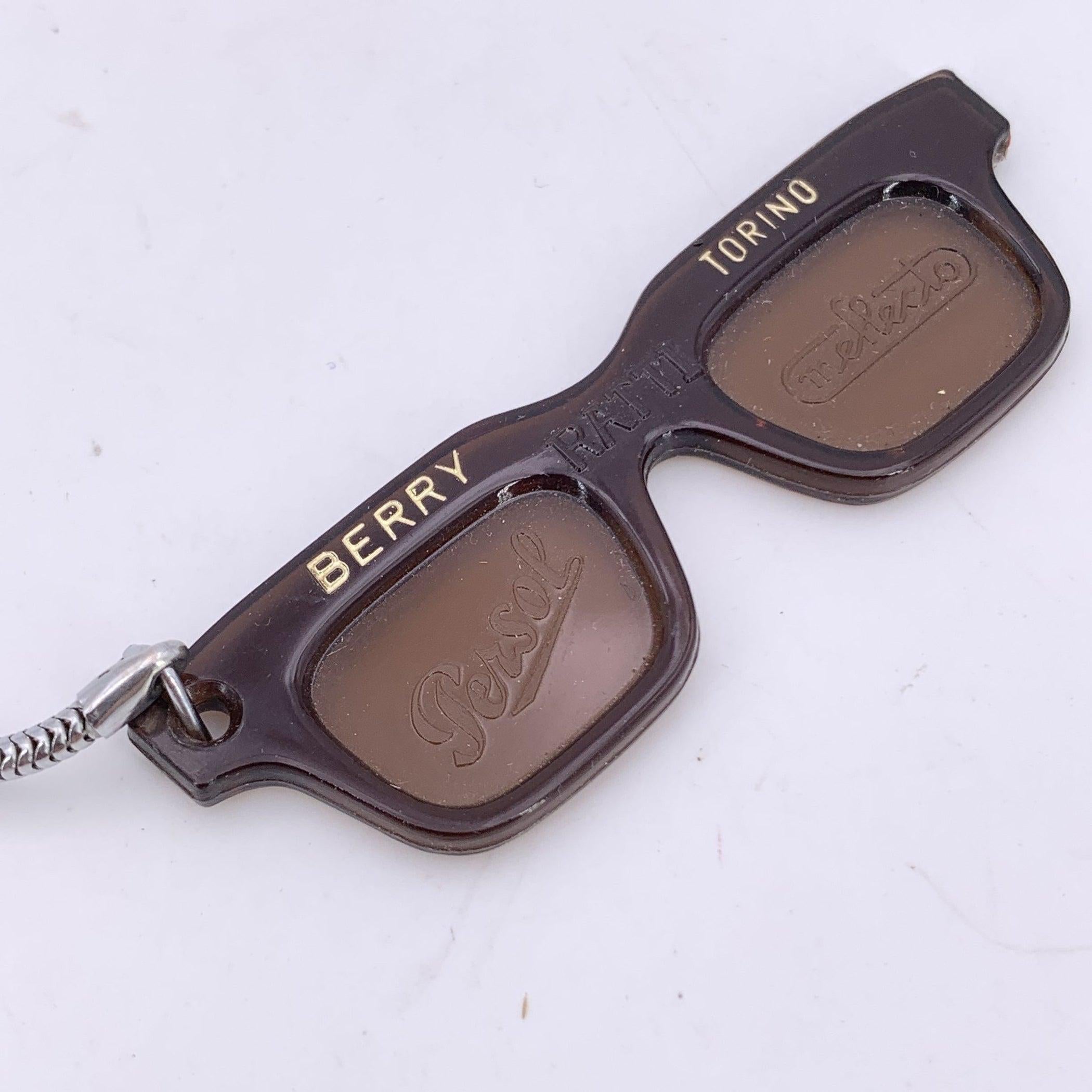 A rare gem for vintage eyewear lovers and collectors alike, this sunglasses-shaped keyring/charm by PERSOL RATTI is a delightful nod to Italian design heritage. Crafted in rich brown plastic, it captures the unmistakable silhouette of Persol's
