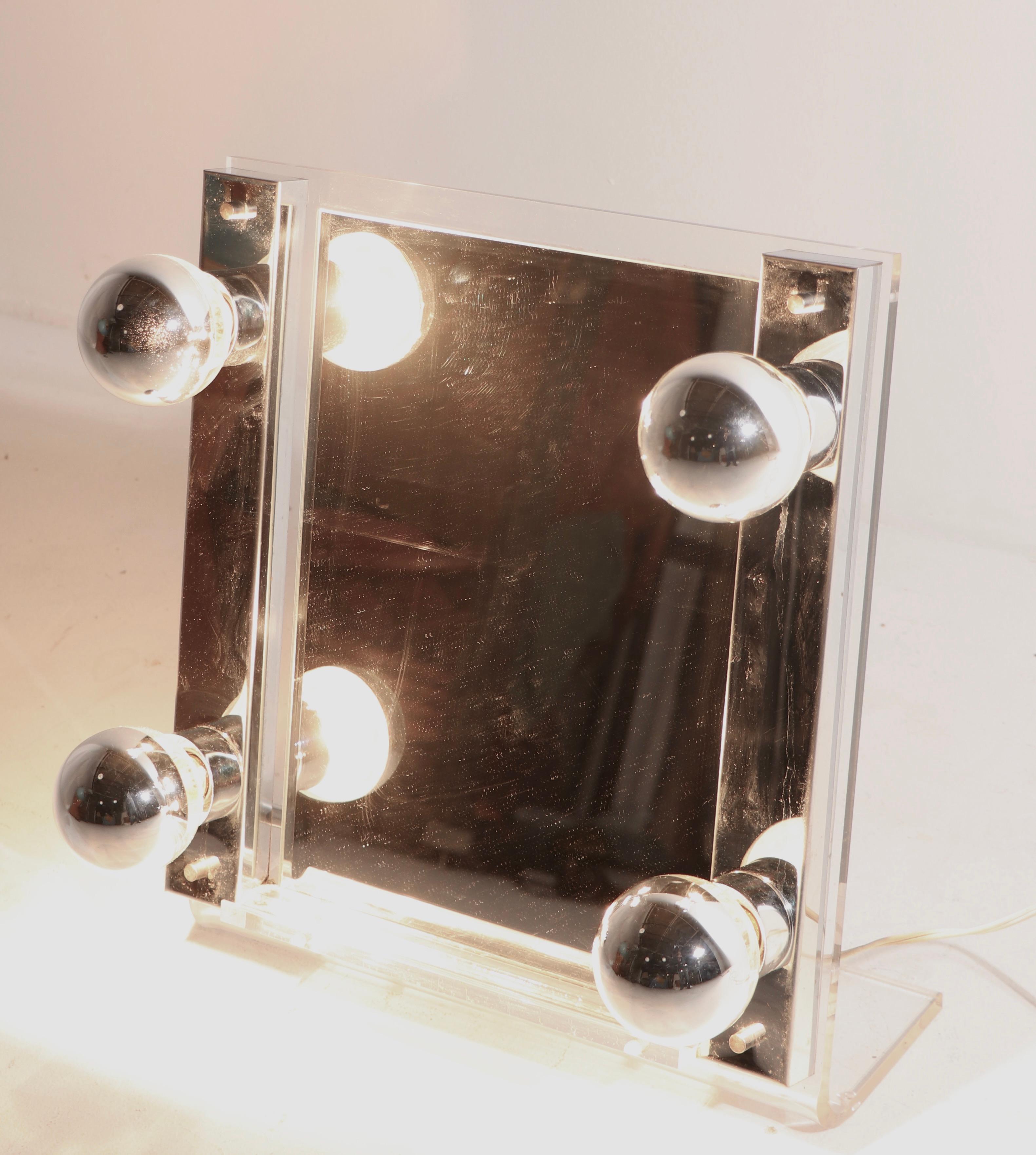 High Style Art Deco Revival make up mirror, table top, vanity mirror. This example features light up bulbs mounted on a canted lucite and chrome frame, which surround the rectangular mirror. Clean, original, and working condition, total glam style,