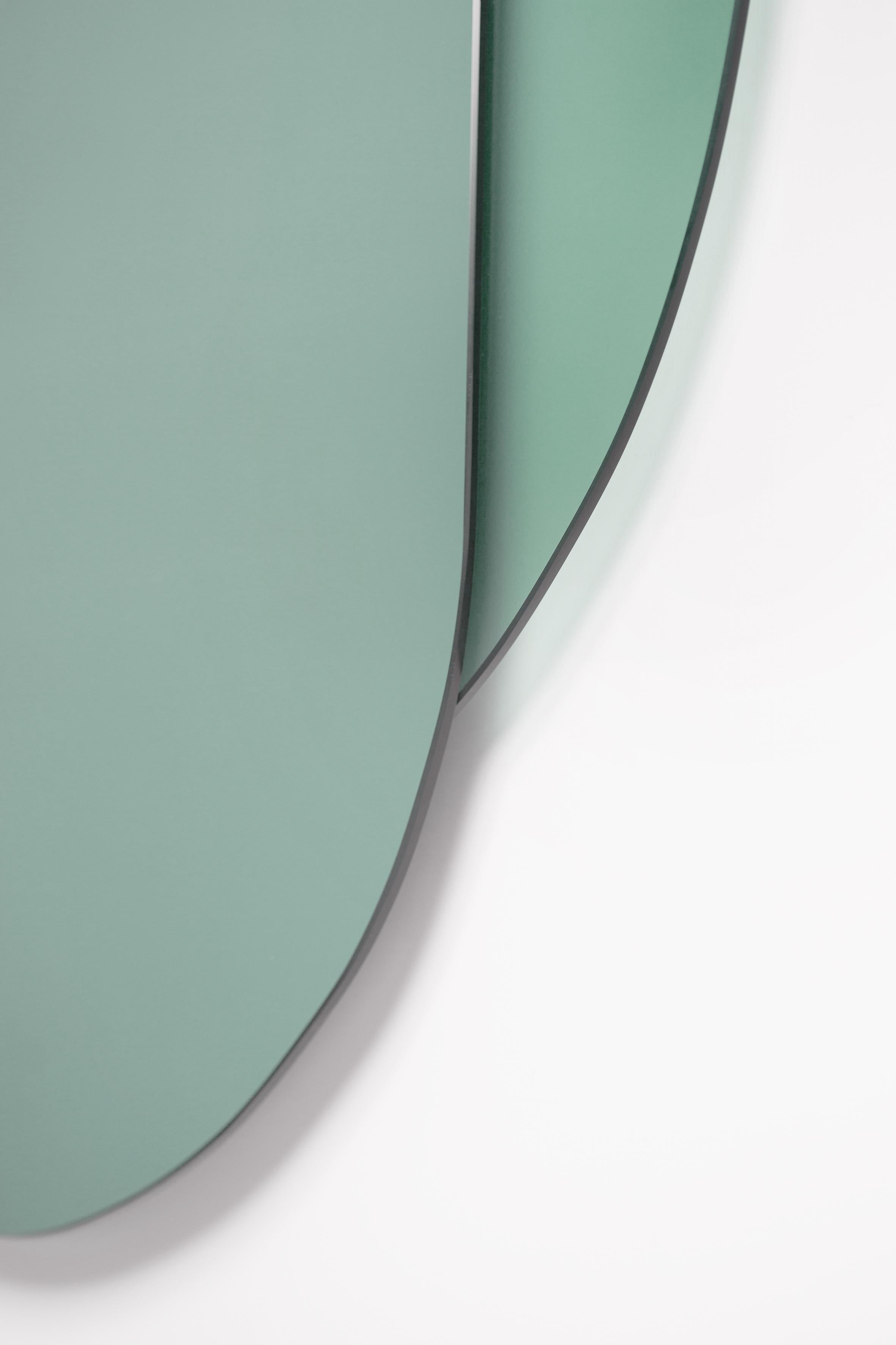 Ce miroir mural juxtapose des verres mats et réfléchissants colorés dans des lignes stylisées de visages masculins et féminins pour laisser un signe de présence sur le mur ou prêter un 