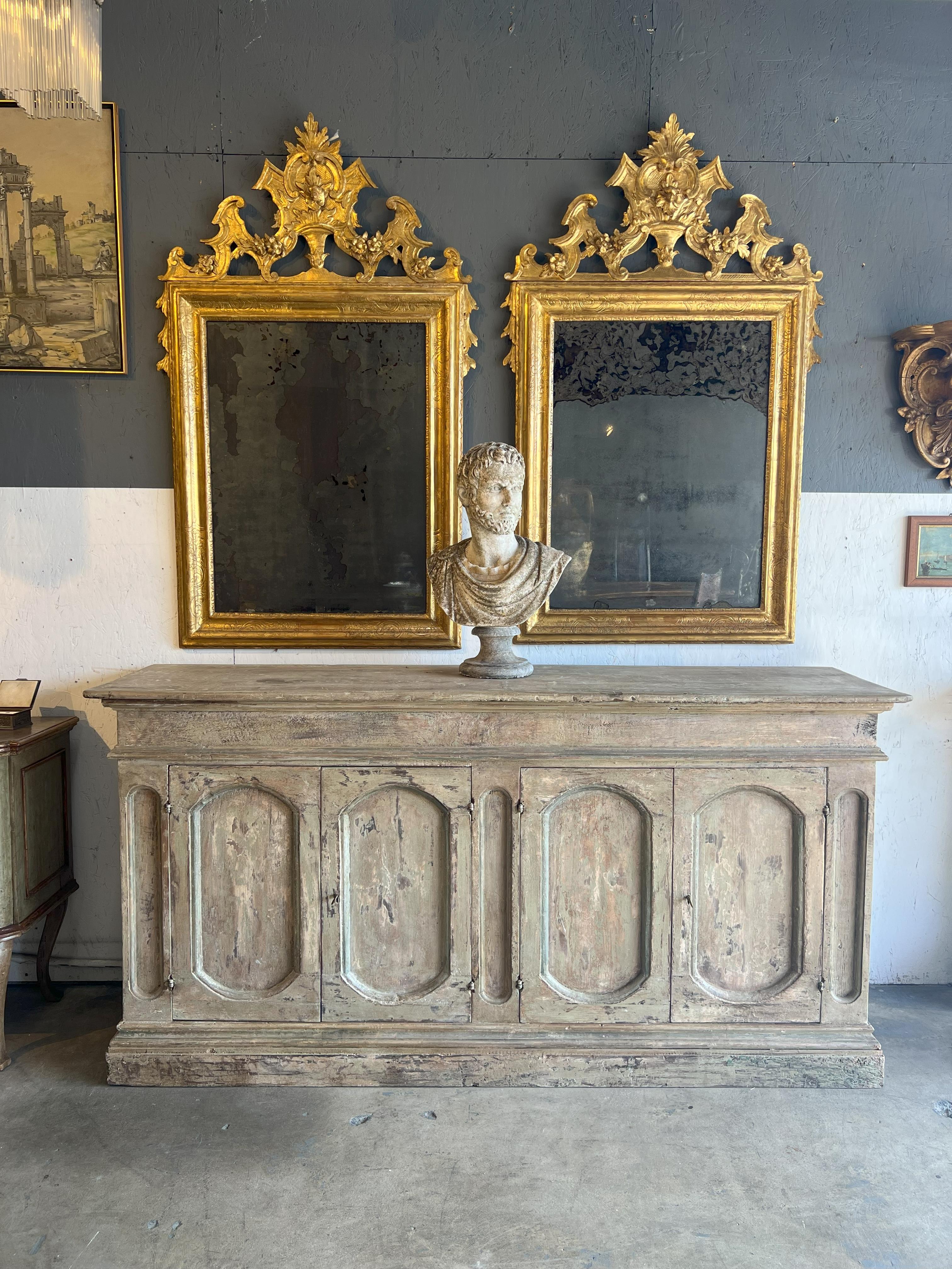 This distressed Credenza Umbra just arrived from Umbria and features a beautiful white painted distress throughout the piece. Perfect for a variety of interiors, this baroque style piece could be a beautiful focal point in any room. The color is a