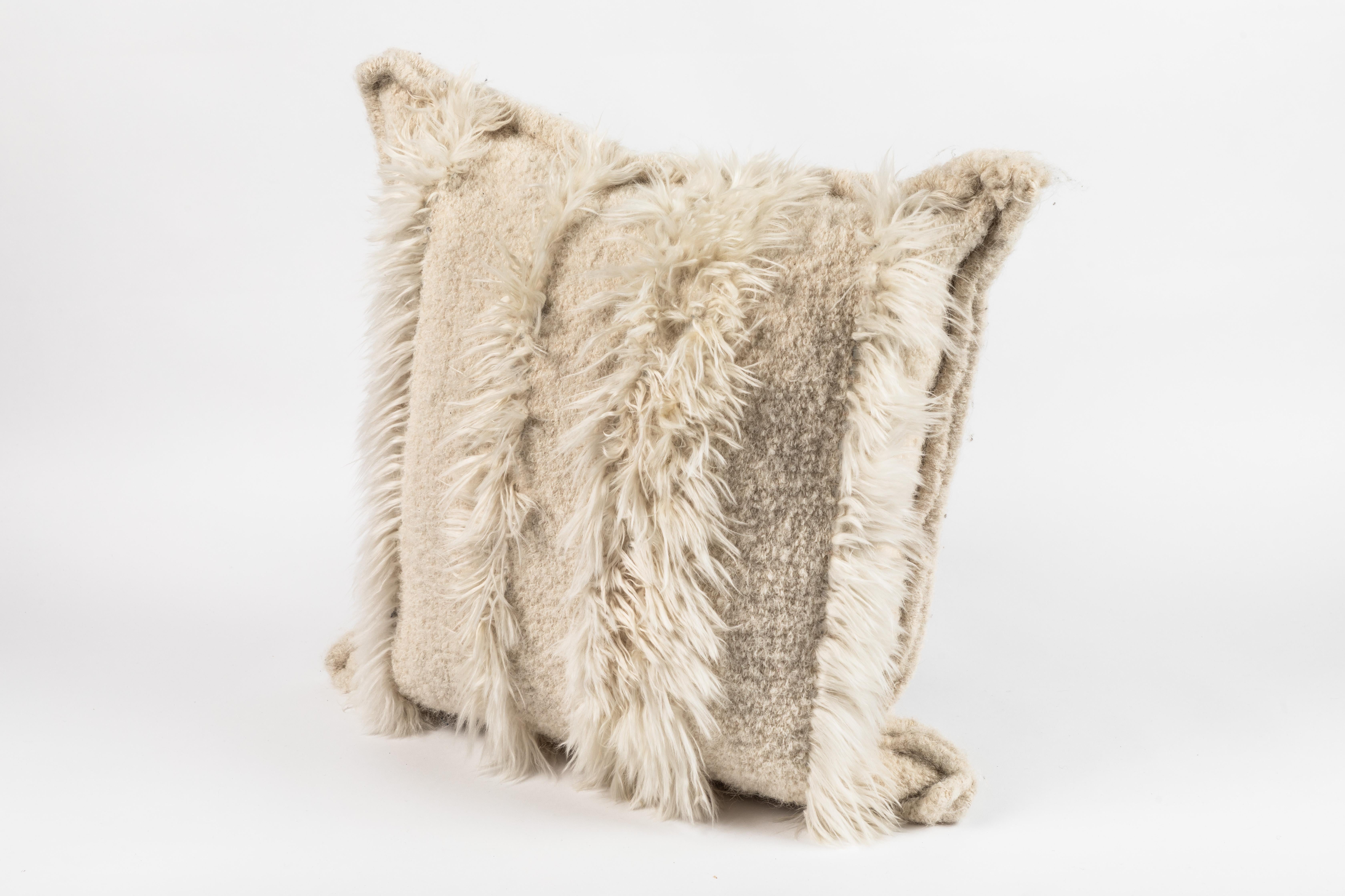 Peruvian alpaca bouclé and suri fur pillow by Rosemary Hallgarten. 

Originating from London, Rosemary Hallgarten is a second generation crafts person who designs and manufactures a luxurious collection of rugs, fabric, pillows and throws made