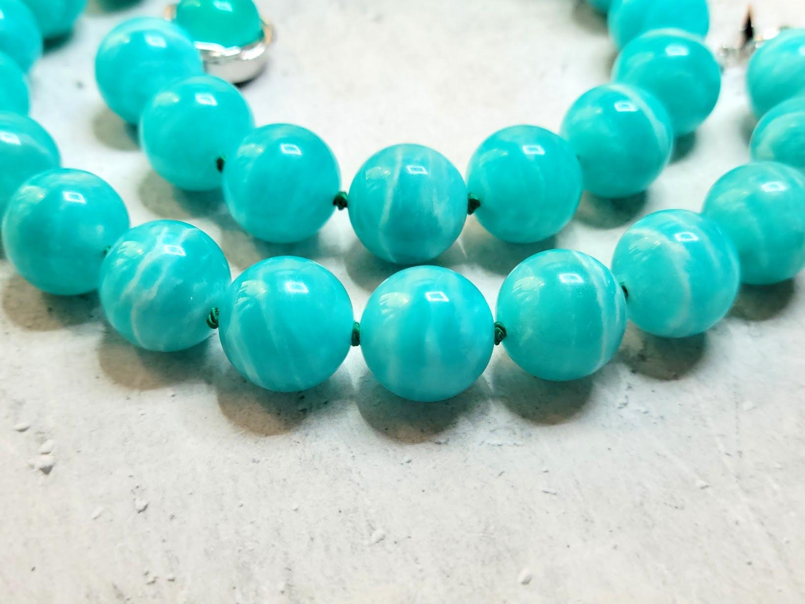 The necklace is 18 inches (45.7 cm) long, and the smooth round beads are 14.5 mm in size.
The beads are sea blue and turquoise, with very subtle soft streaks. We are guaranteed 100% natural Peruvian Amazonite, not treated in any way. The beads are