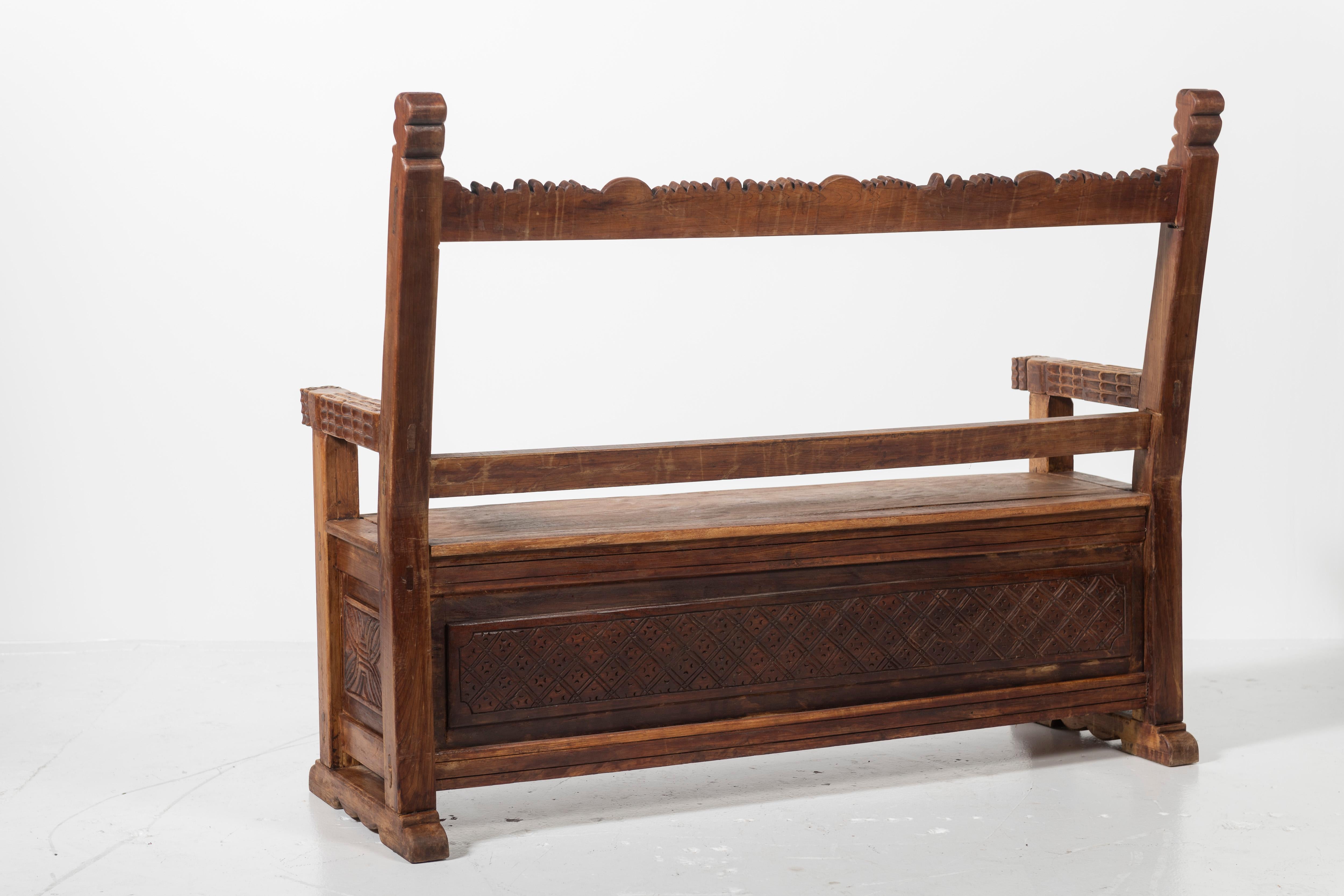 Beautifully carved mahogany bench with storage is functional and interesting from every angle.