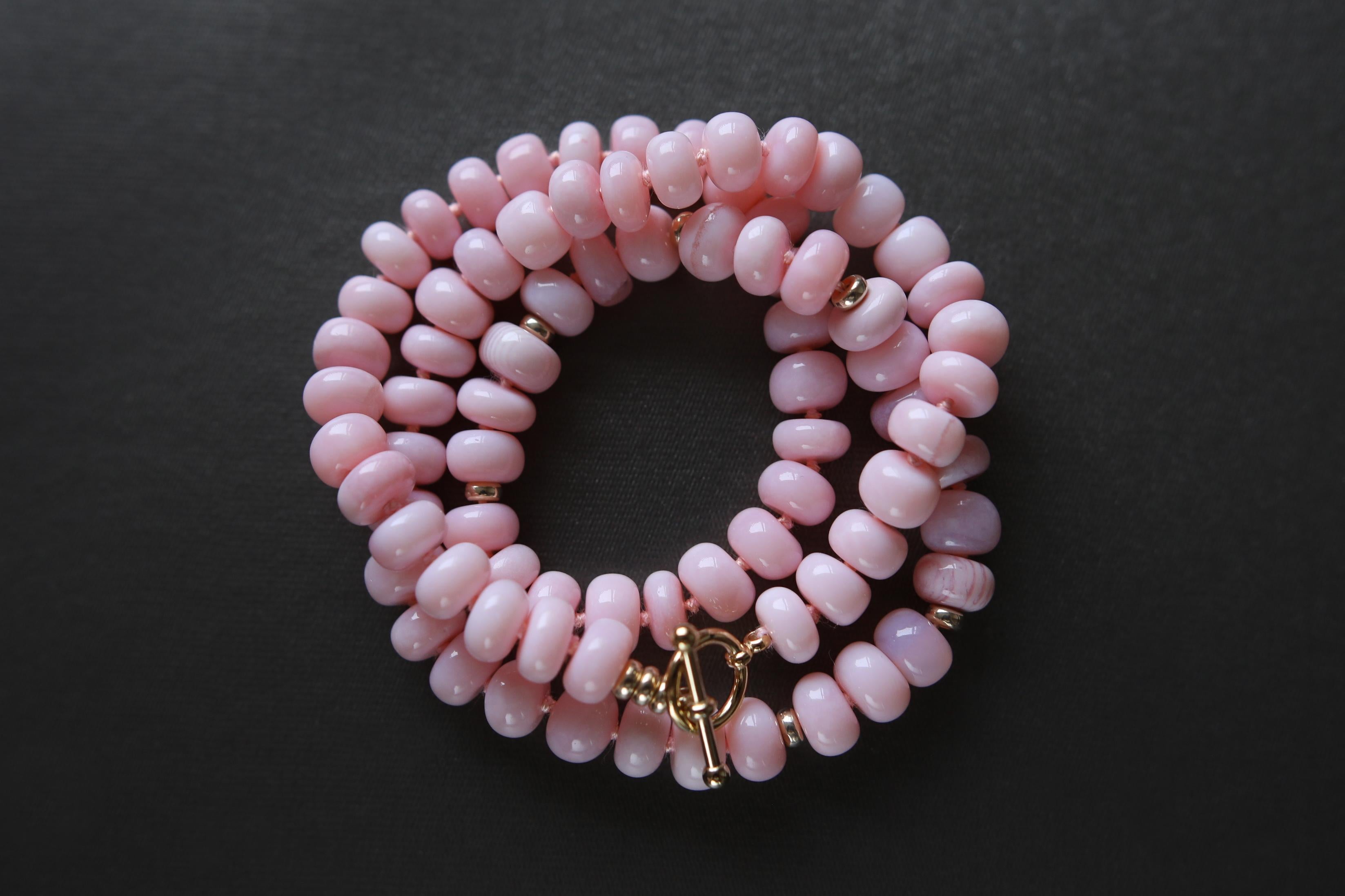 A fashion favorite, stunning natural gem quality Peruvian Pink Opal bead bracelet/necklace with seven evenly dispersed yellow gold beads and gold plated toggle clasp. Each 8.5 mm bead is knotted with silk cord. Handmade in San Francisco. 
This