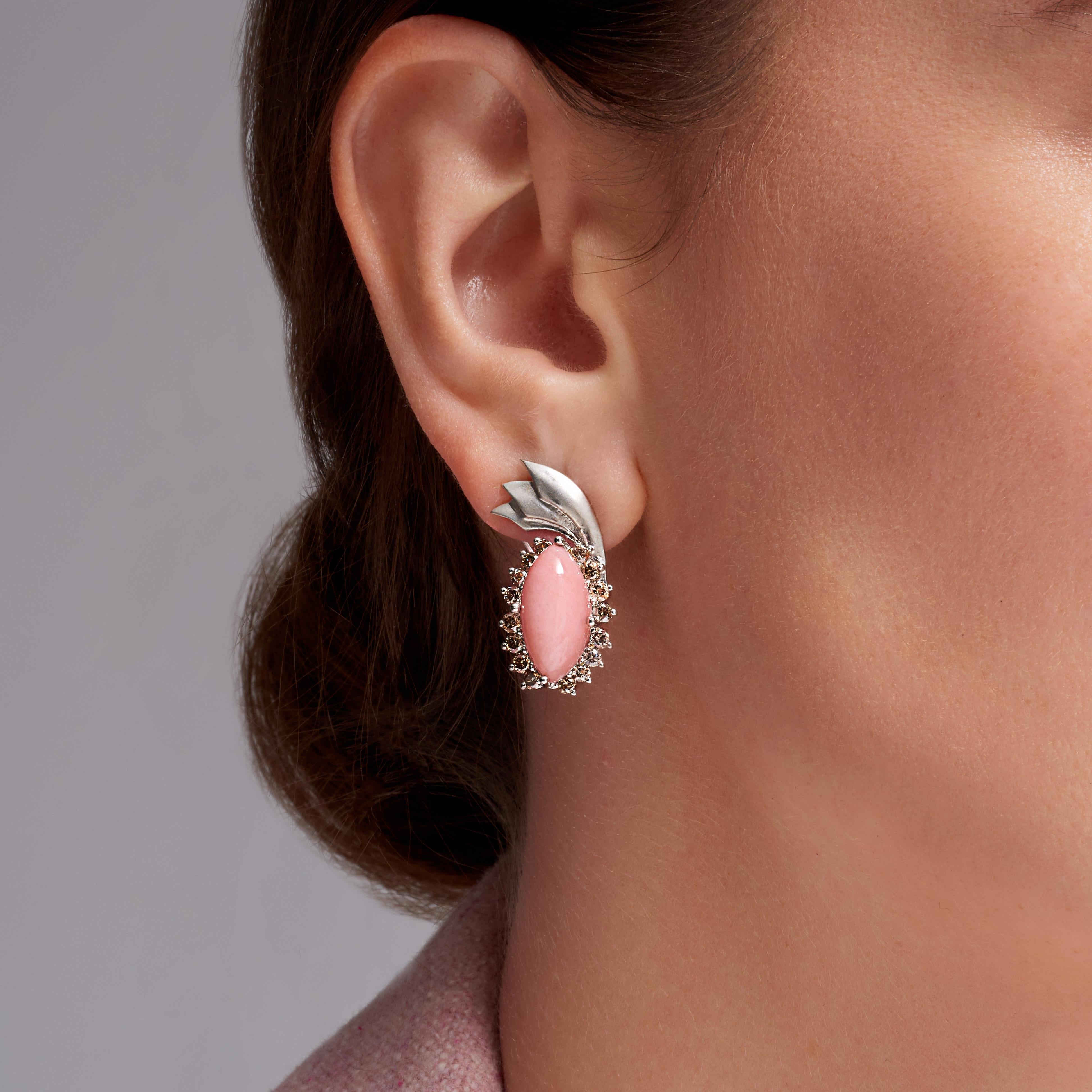 Peruvian Pink Opal Champagne Diamond 18k White Gold Drop Earrings, In Stock.

These earrings feature a large Peruvian Pink Opal as the center stone of the earrings. Surrounding the pink opal are 1.6-carat total-weight natural color champagne