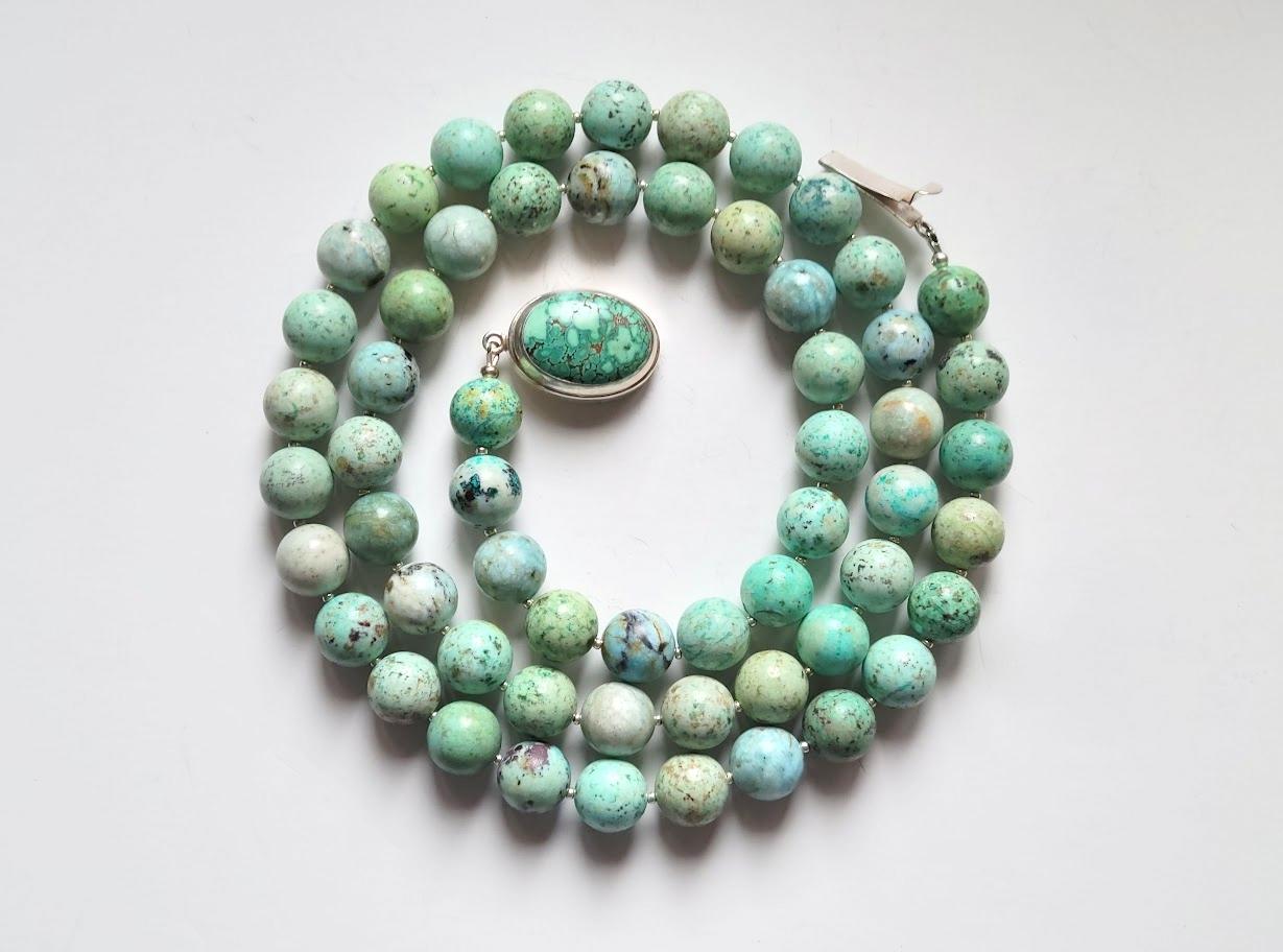 The necklace is 36 inches (91 cm) long. The smooth round beads are 14 mm in size.
Peruvian turquoise beads are simply stunning! We were thrilled to find this stone, with its gorgeous light blue-green color. Each stone, a blend of copper and