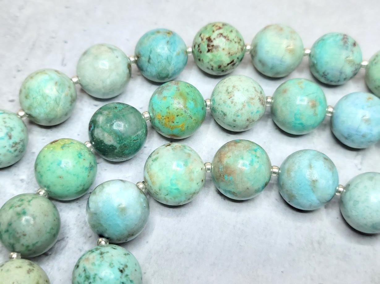 The necklace is 33.5 inches (85 cm) long. The smooth round beads are 12 mm in size.
Peruvian turquoise beads are simply stunning! We were thrilled to find this stone, with its gorgeous light blue-green color. Each stone, a blend of copper and