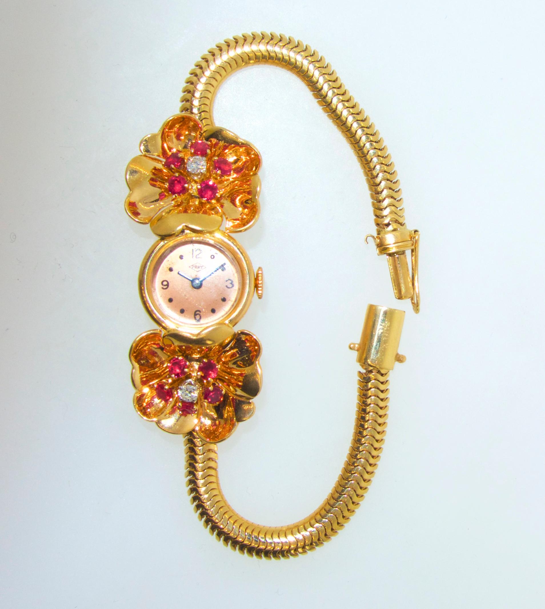 Bright red natural rubies and white diamonds create a flower motif within reflecting gold.  The watch by Pery is a manual wind in fine condition and recently services.  The watch bracelet is a good length to fit most wrists.  The clasp is well done.