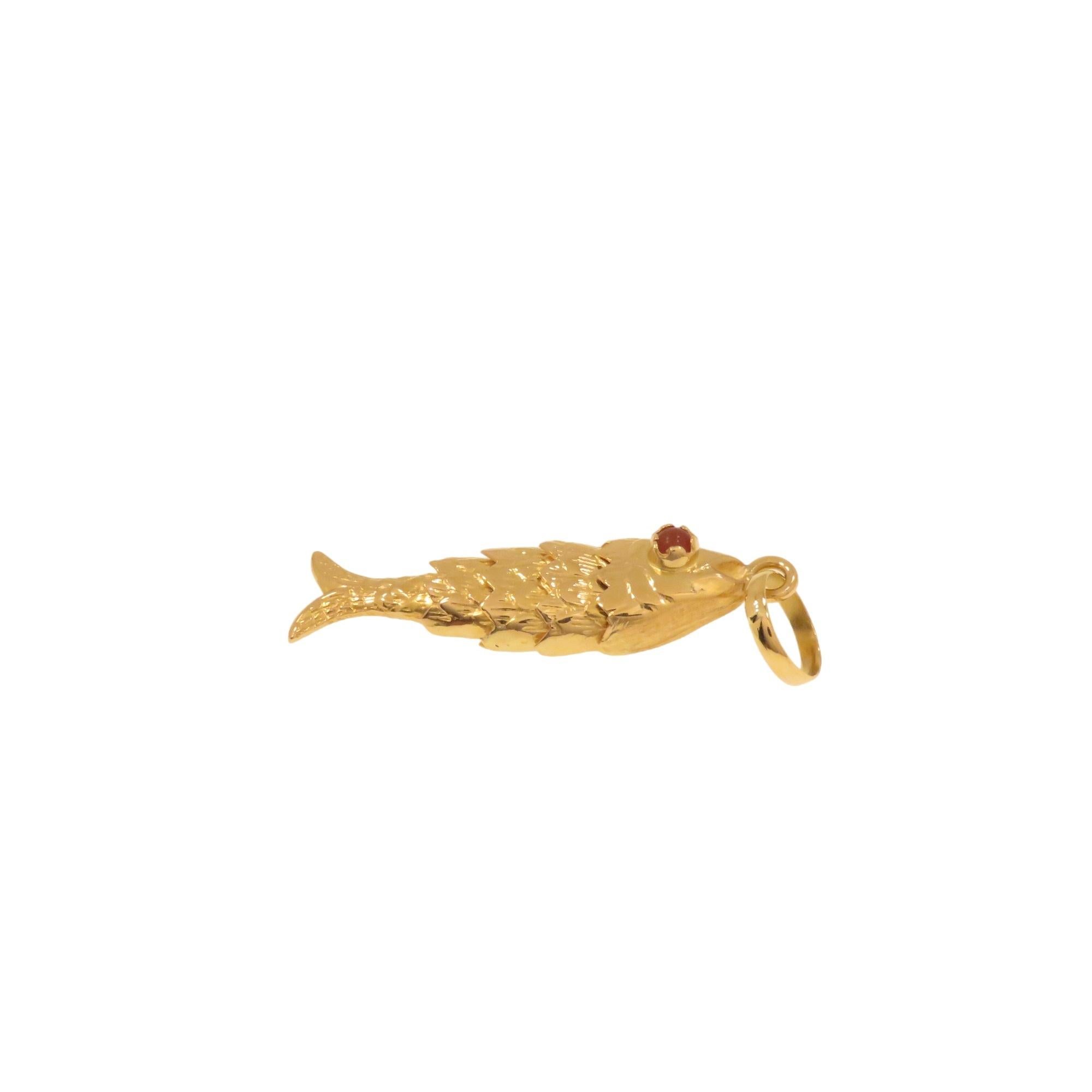 Stunning fish-shaped pendant handmade in Italy between 1960 and 1970. It features a realistic fish with an articulated body that allows it to imitate the natural aquatic movements of a fish. The body is 18-karat yellow gold, and the eyes are adorned