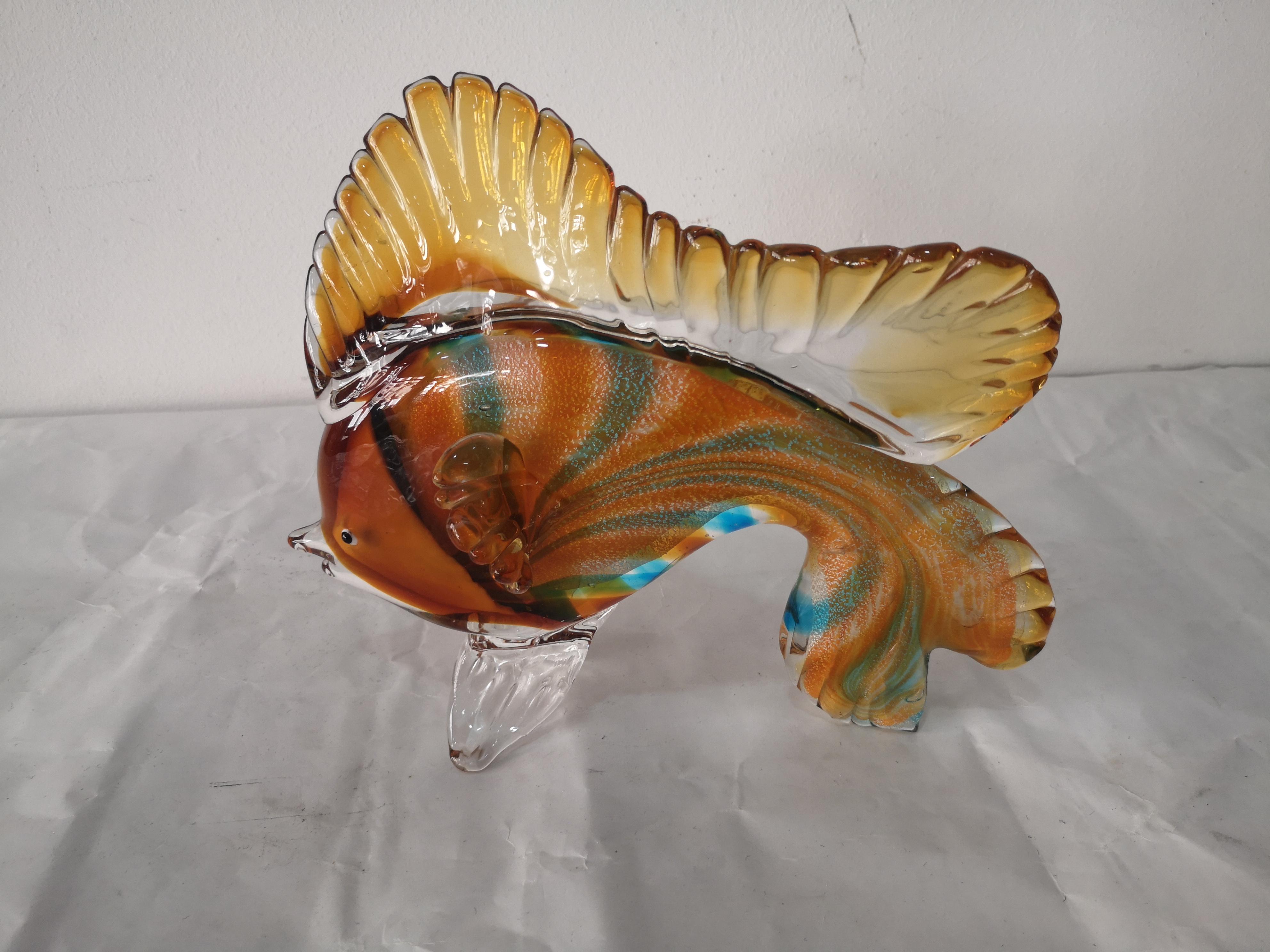 Scultura di pesce ornamentale in vetro di Murano. Questo tipo di oggetto è un esempio di artigianato veneziano, rinomato per la sua maestria e i disegni intricati. 
La scultura è realizzata a mano da maestri vetrai, utilizzando tecniche tradizionali