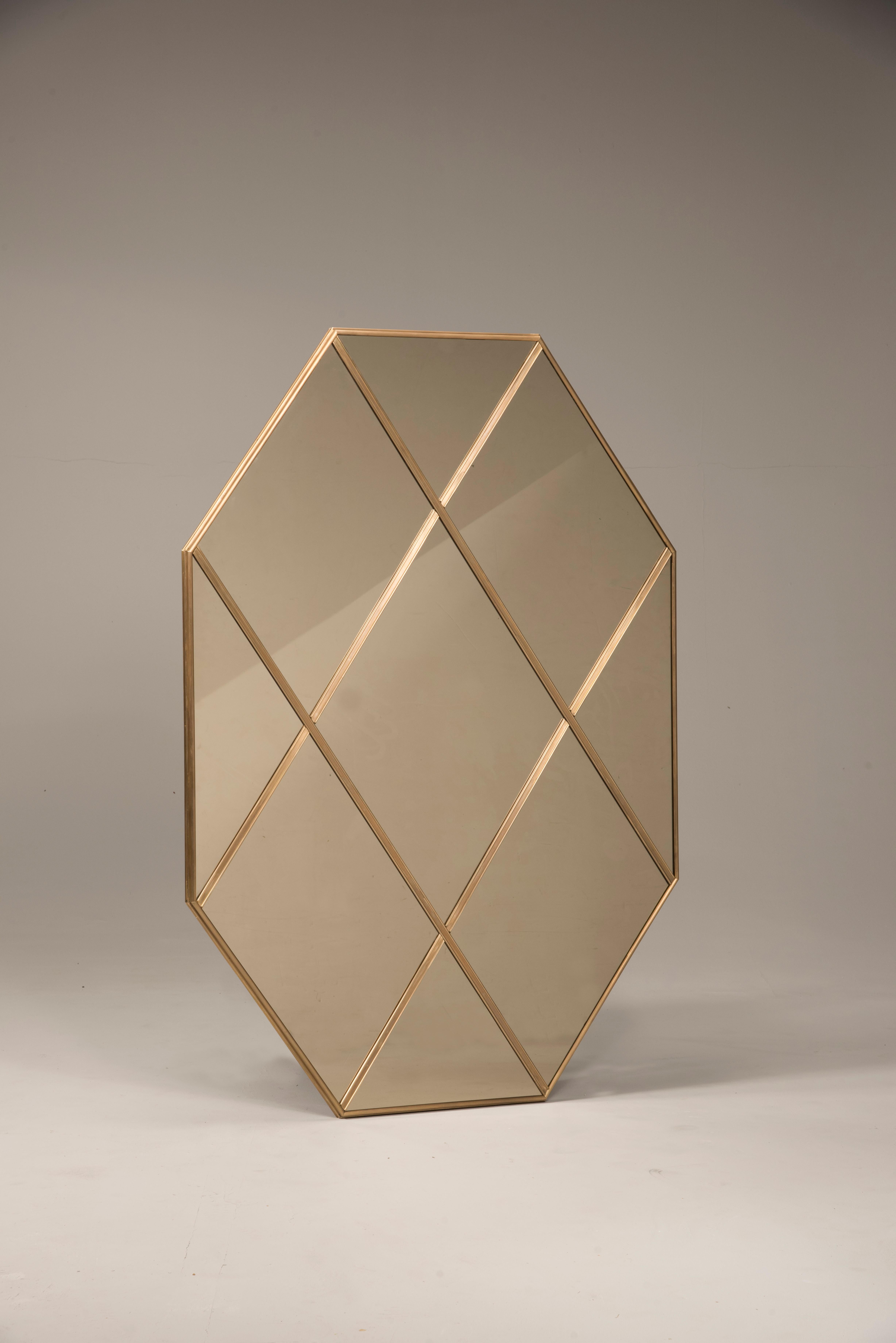 Pescetta presents its new collection of contemporary customizable mirror. Here, a brass frame panelled warm bronze glass mirror. With frame made of brass, mitred corners and multi panels, these mirrors replicate those ones produced during the gold