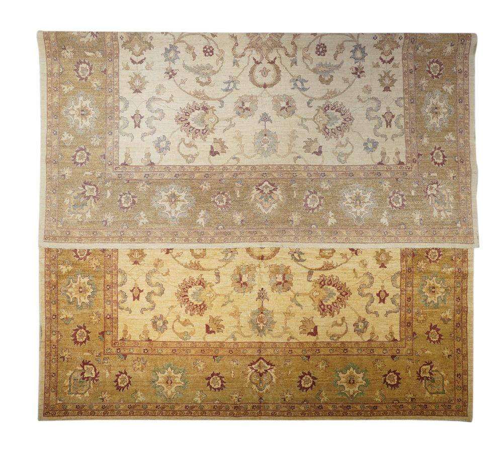 Peshawar Rug 12'6'' x 17'5''. The lightly abrashed straw-sand field displays a four-way symmetric pattern of straight and volute spiral vines, anchored by petal palmettes, and further accented with serpentine cloud bands. Rust and green accents.