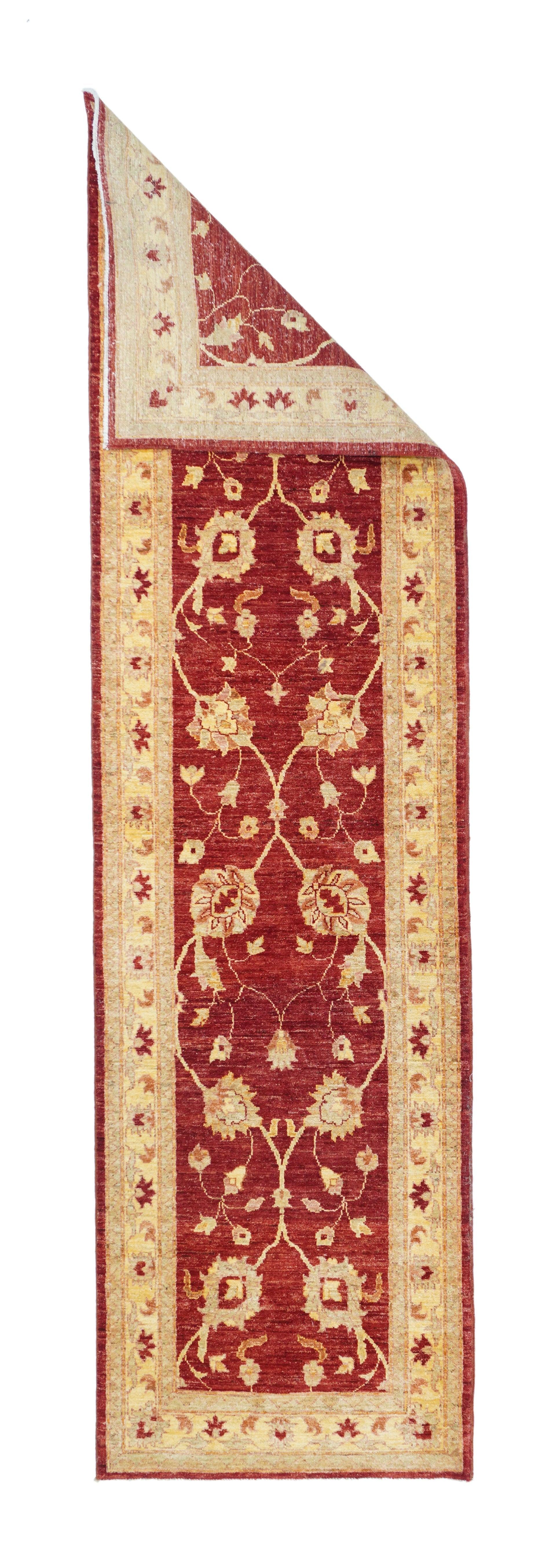 Runner Peshawar 2'8'' x 10'0''. Il campo rosso, caldamente abraso, presenta un doppio motivo a meandro di viti verticali ondulate e intersecanti, ancorate da palmette inclinate e stracciate. Secondario vinoso leggero con boccioli. Bordo in paglia