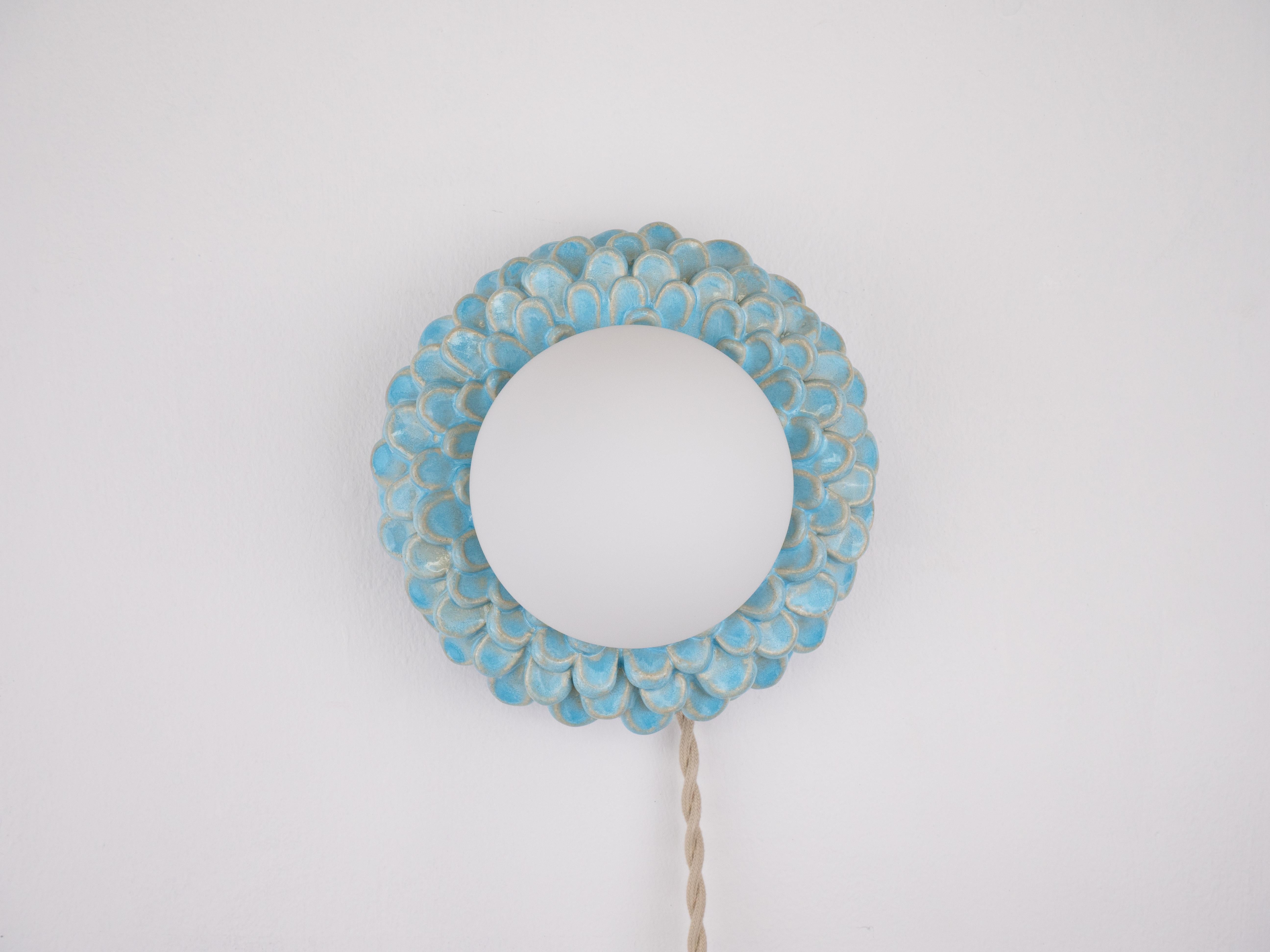 This handmade ceramic wall light has the loveliest flower-like design with a glowing centre that will add a warm touch to any space. With its delicate, glossy petals, it’s a fun mix of quirky and stylish.

Bulb is included
Bulb fitting: G9
Glass