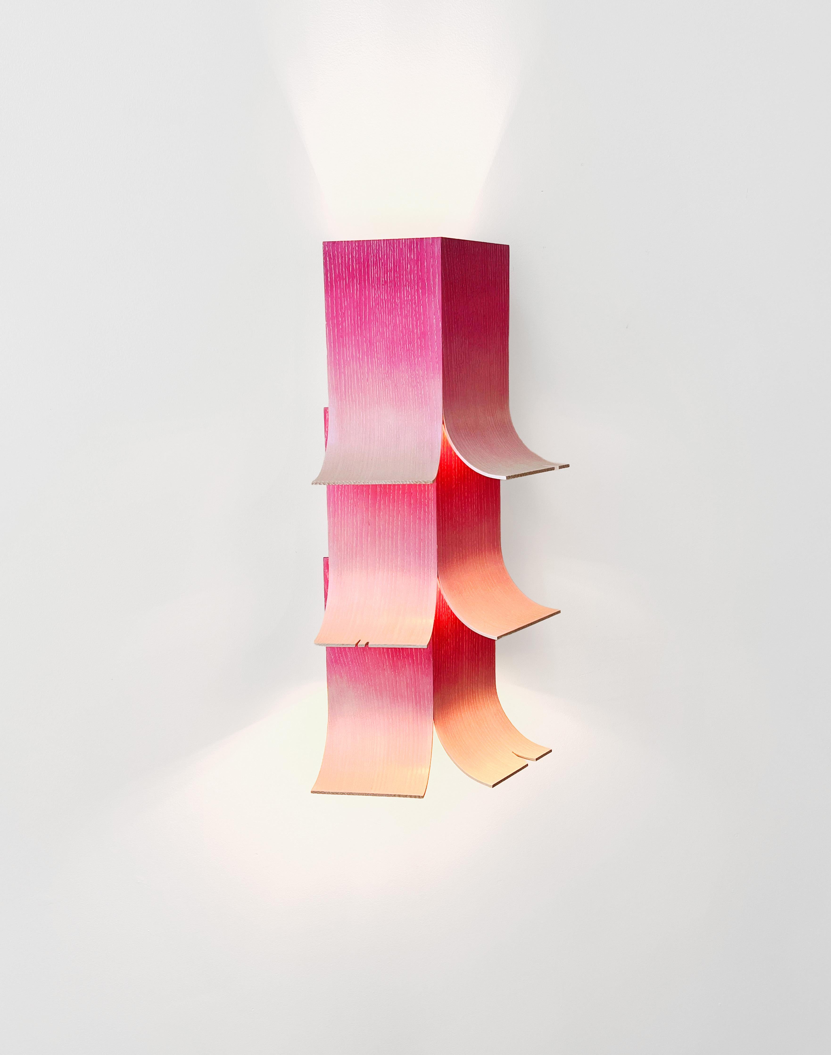 Il Petal Sconce si ispira agli angoli degli edifici con le tegole, agli abiti con il colletto e alle fioriture primaverili. Le persiane ricurve e drappeggiate creano linee del tetto e petali con la luce che filtra da aperture simili a soffitti e che