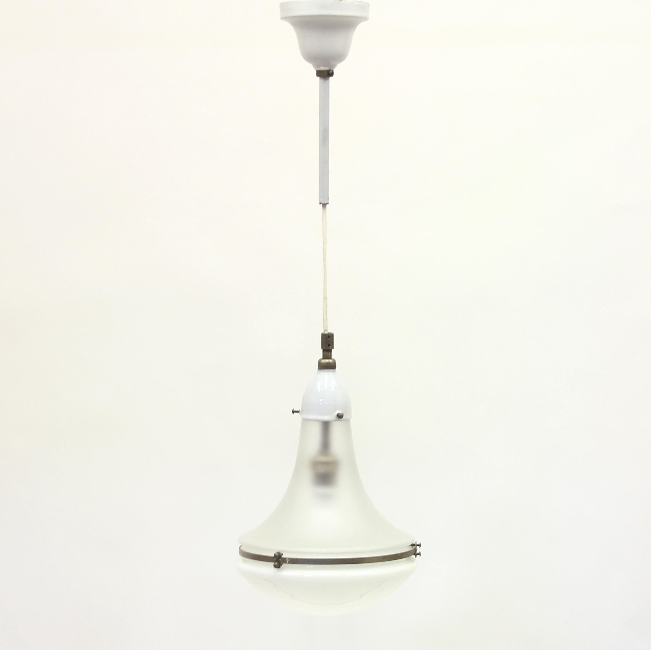 Classic Peter Behrens design piece from around 1910 and was manufactured in Germany, by AEG or SSW Siemens-Schuckert-Werke GmbH. A frosted white glass shade is held in place by a bell-shaped metallic attachment and stem, encasing the bulb for the