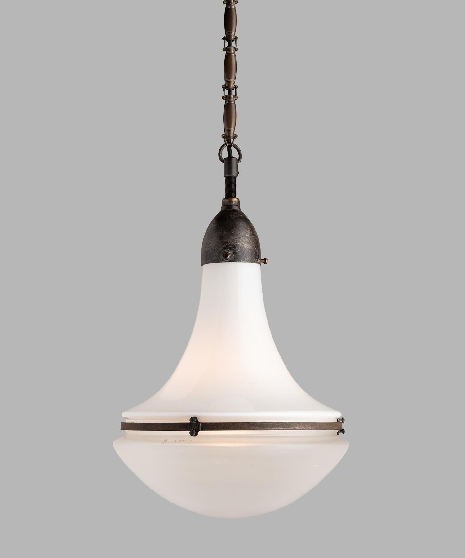Peter Behrens Luzette pendant, Germany, circa 1920.

Custom order of (3) pendants with opaline glass top and frosted glass bottom, secured with patinated steel fitter and brace. Each light is unique with slight variance in patina and condition.
