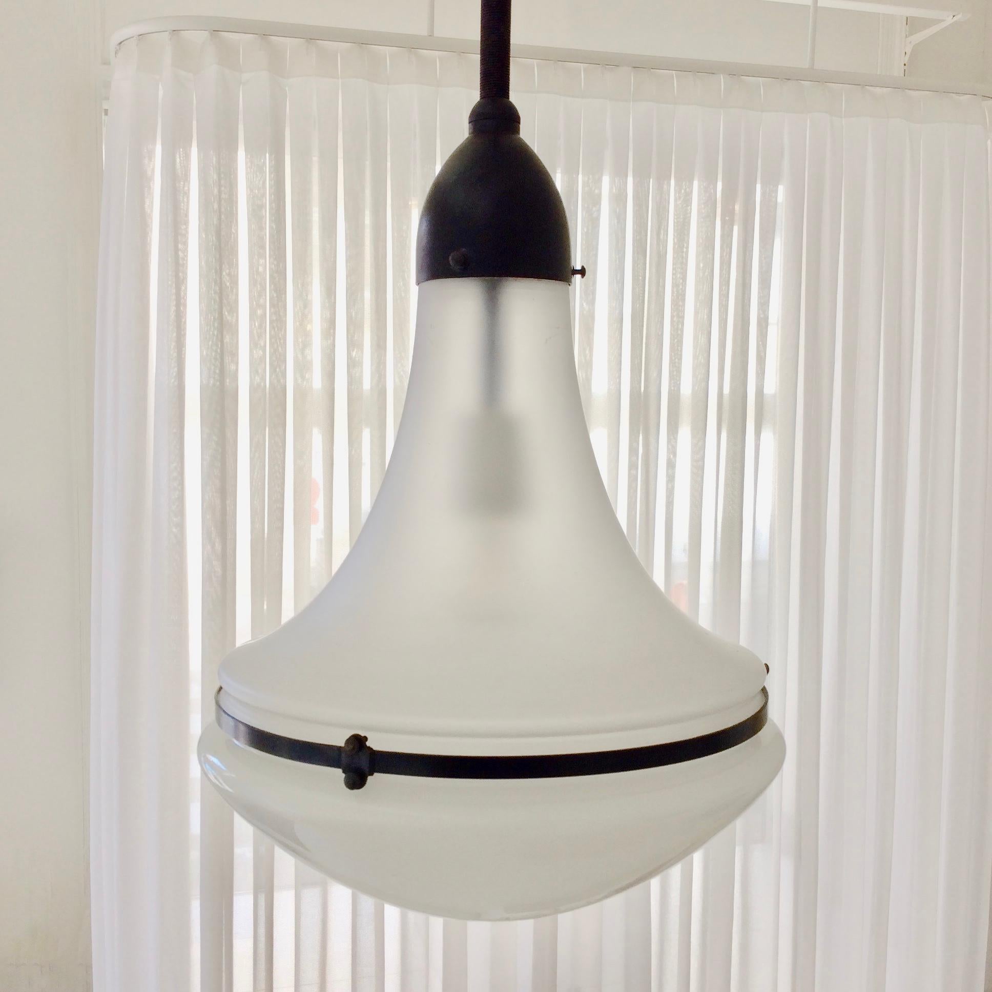 Peter Behrens Luzette pendant lamp, circa 1910, Germany.
Opaline white glass and frosted glass are assembled by metal ring and screws in patinated metal.
One E 27 bulb of 60 W.
Original chain, original condition.
Dimensions: 124 cm height, diameter