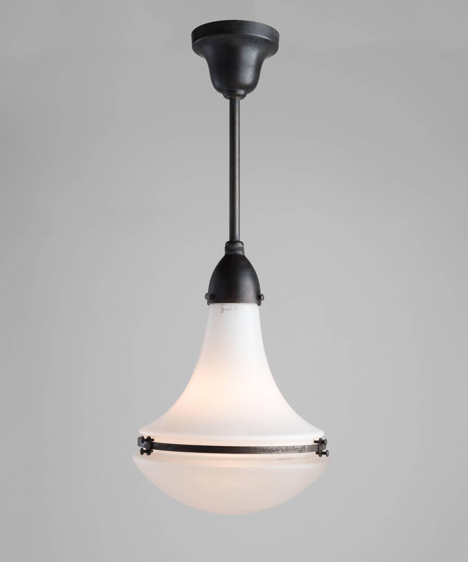 Peter Behrens Luzette pendants, circa 1920.

Opaline glass top with frosted glass bottom secured with copper fitter and brace. Manufactured by AEG Siemens with manufacturer's mark.

Primary element height is 12
