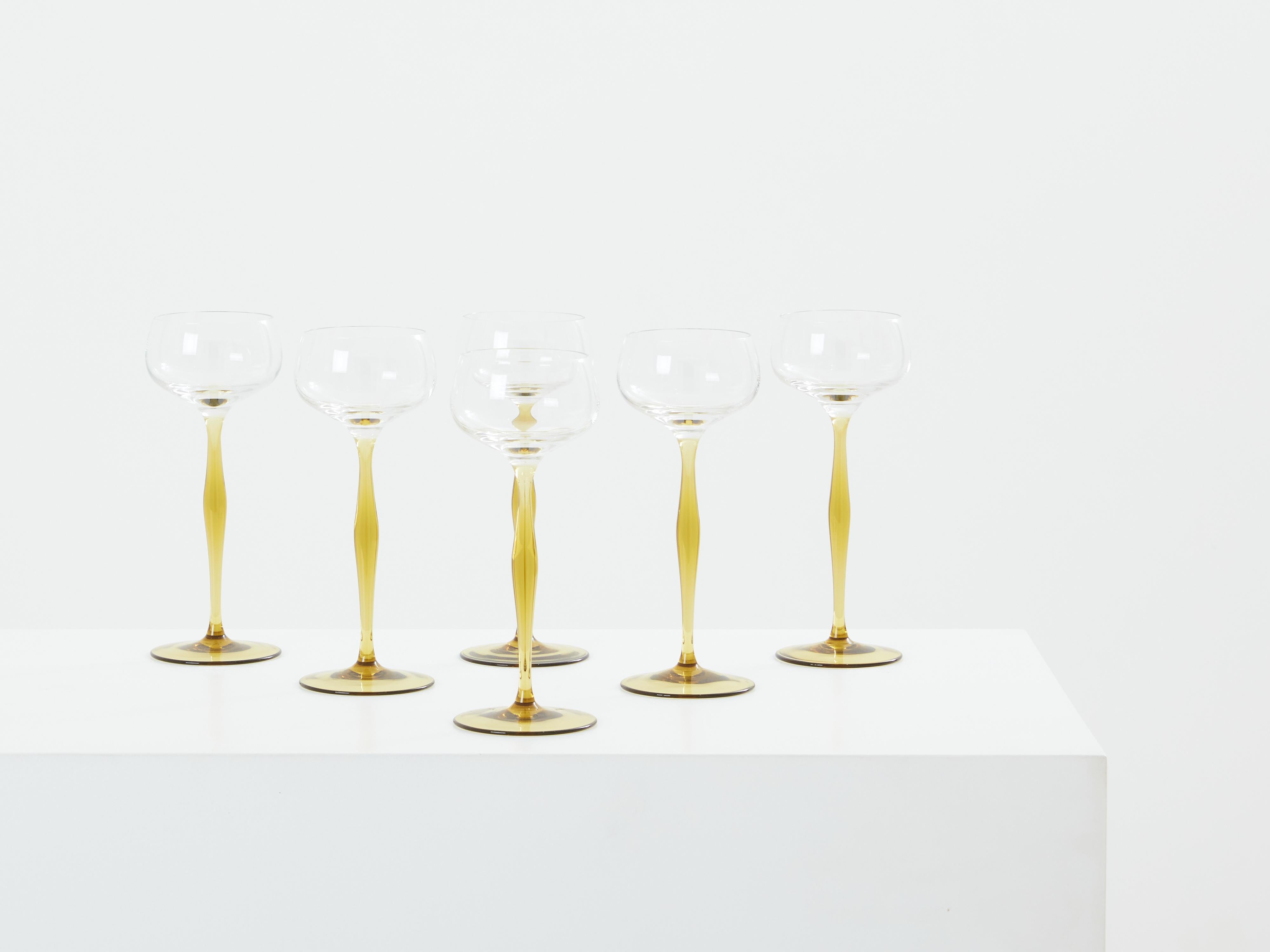 This set of six champagne glasses, designed by Peter Behrens for Benedikt von Poschinger, dating back to 1898, embodies a skillful blend of innovation and aesthetics. Each glass features a domed bowl of transparent glass mounted on a long stem of