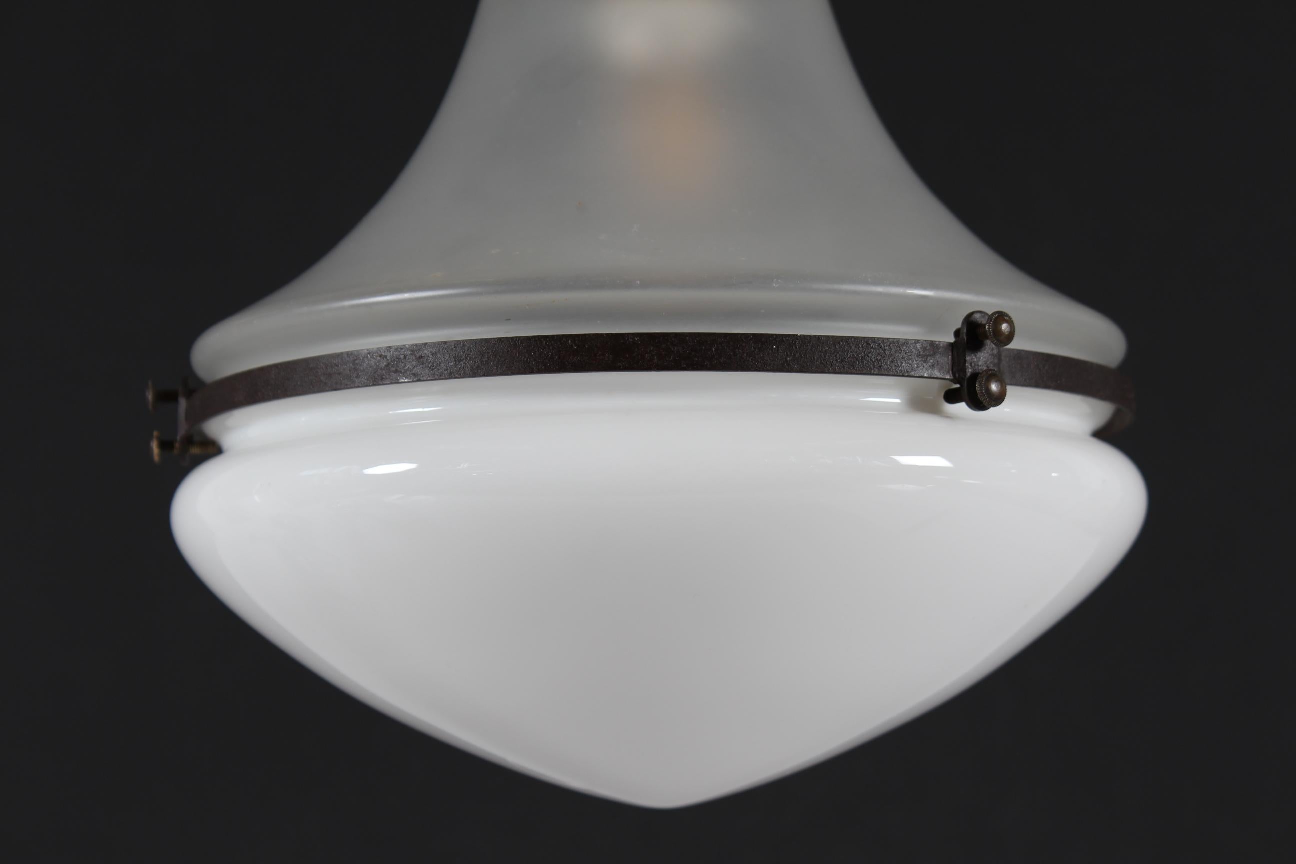 Bauhaus-Pendelleuchte Luzette in kleiner Ausführung, entworfen von Peter Behrens im Jahr 1908 für Siemens-Schuckert.
Die Pendelleuchte hat einen unteren Schirm aus Milchglas und einen oberen Schirm aus milchweißem Opalglas. Der Schirm hat