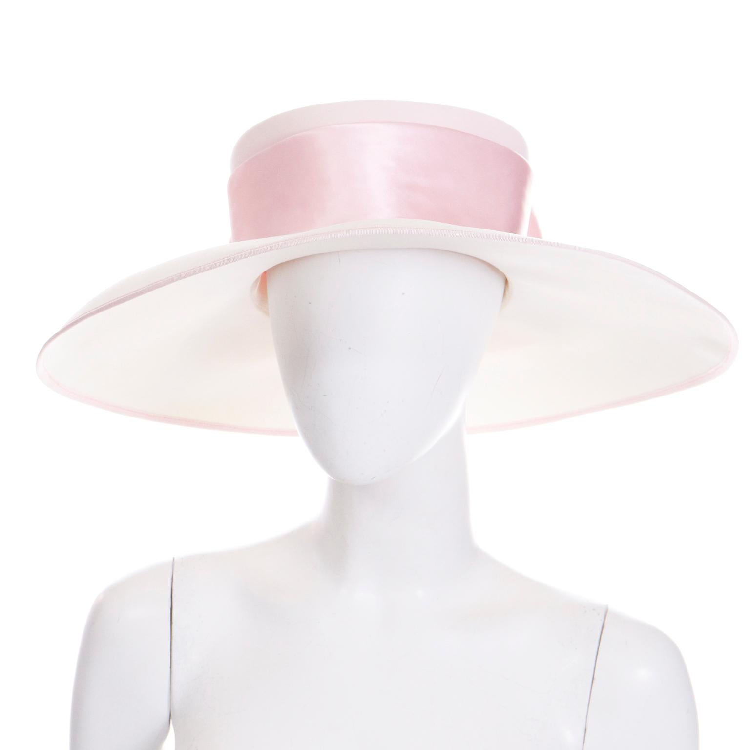 This is a lovely vintage Peter Bettley London 1980's wide brimmed hat in cream with a wide pink satin bow and ribbon on the crown. The perimeter of the brim is trimmed in a pink grosgrain ribbon. We especially love the way the brim is wider in the