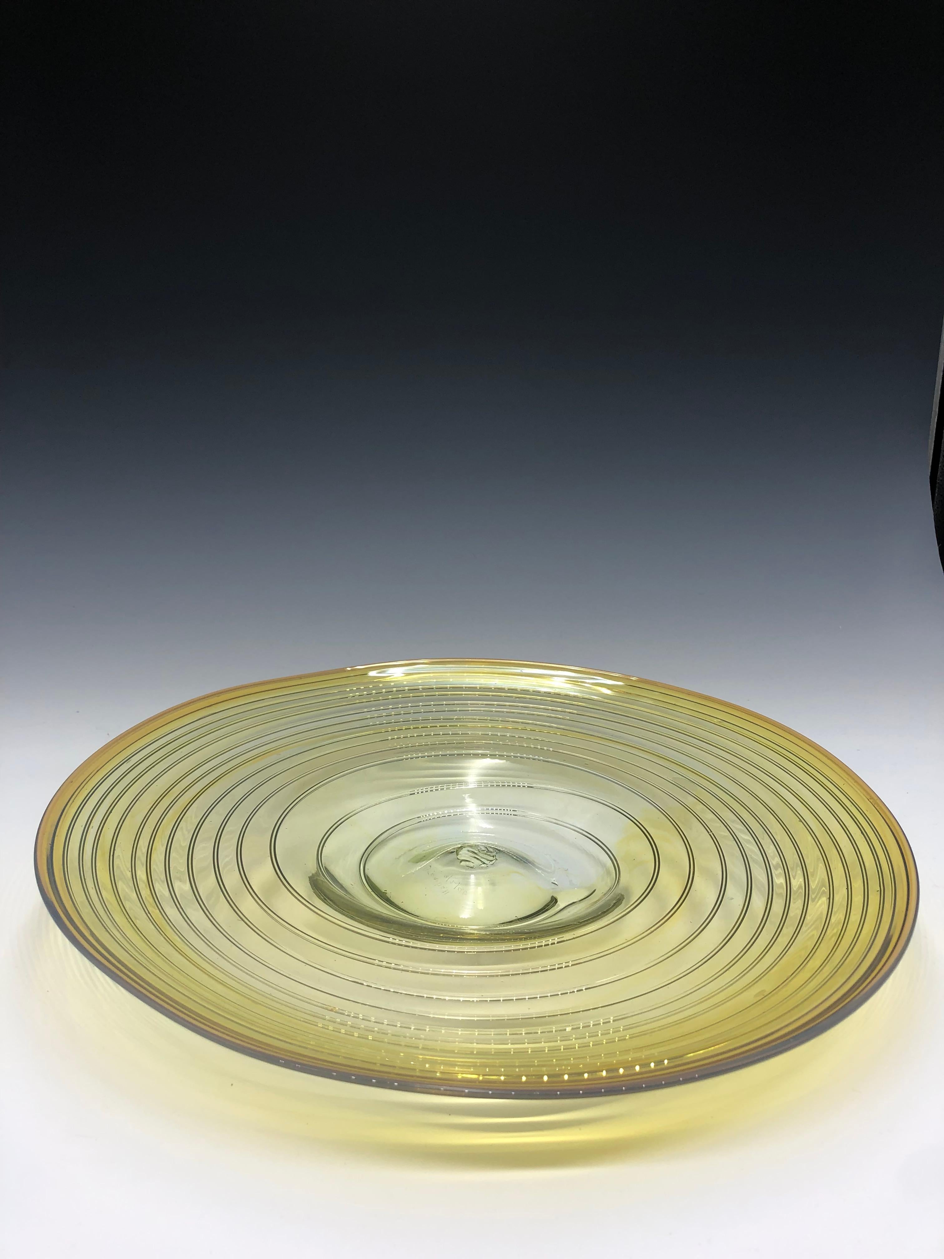 Beautiful vintage yellow glass sculpture centerpiece created by Peter Bramhall, signed and dated 8/2/80 on the base.   

Size: 15" diameter x 1.5" tall   

The swirl design platter is uniquely shaped and fully hand-blown, leaving a subtle pontil