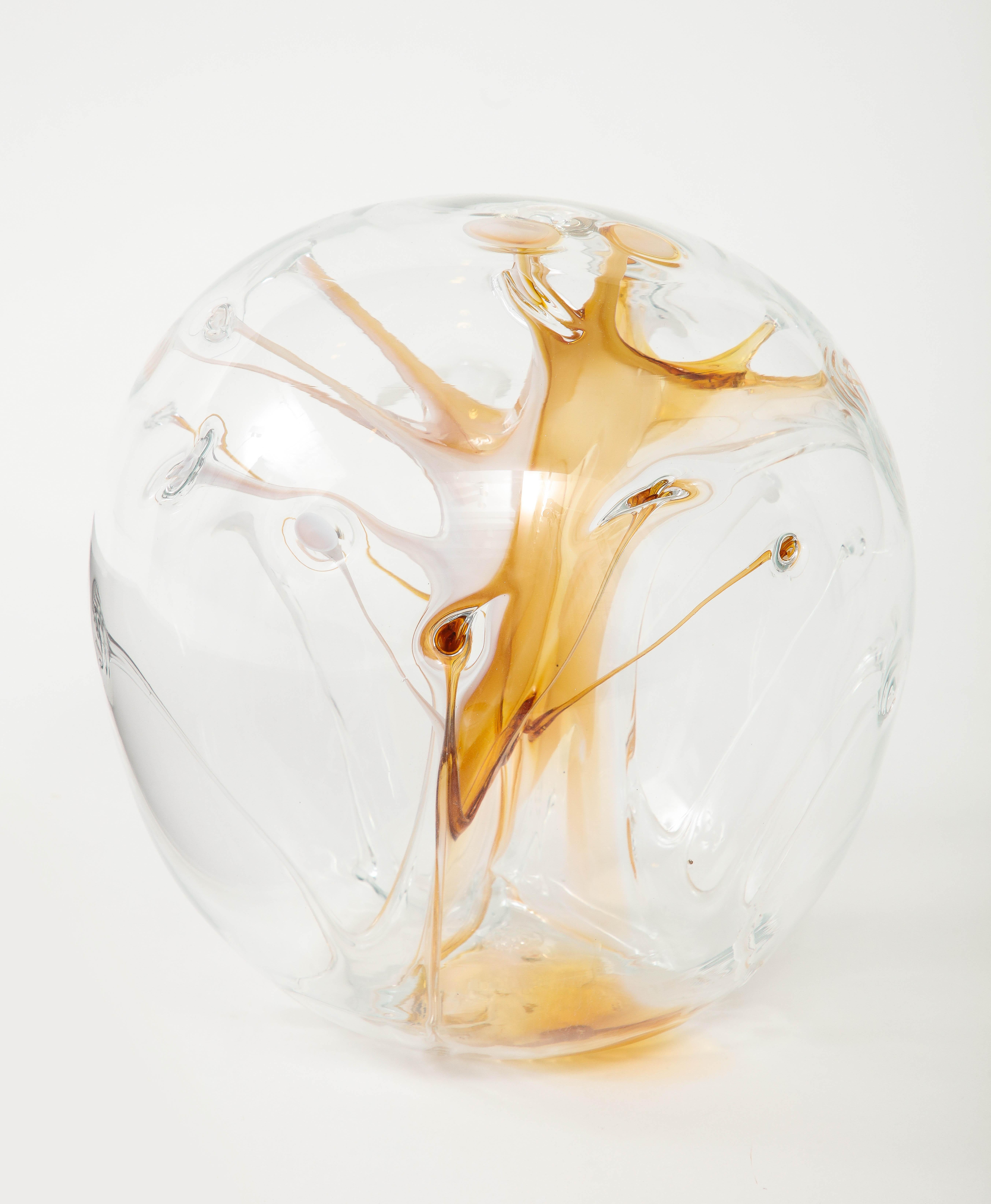 Eye catching hand bown glass orb with amber/honey colred internal glass threads. Signed on bottom.