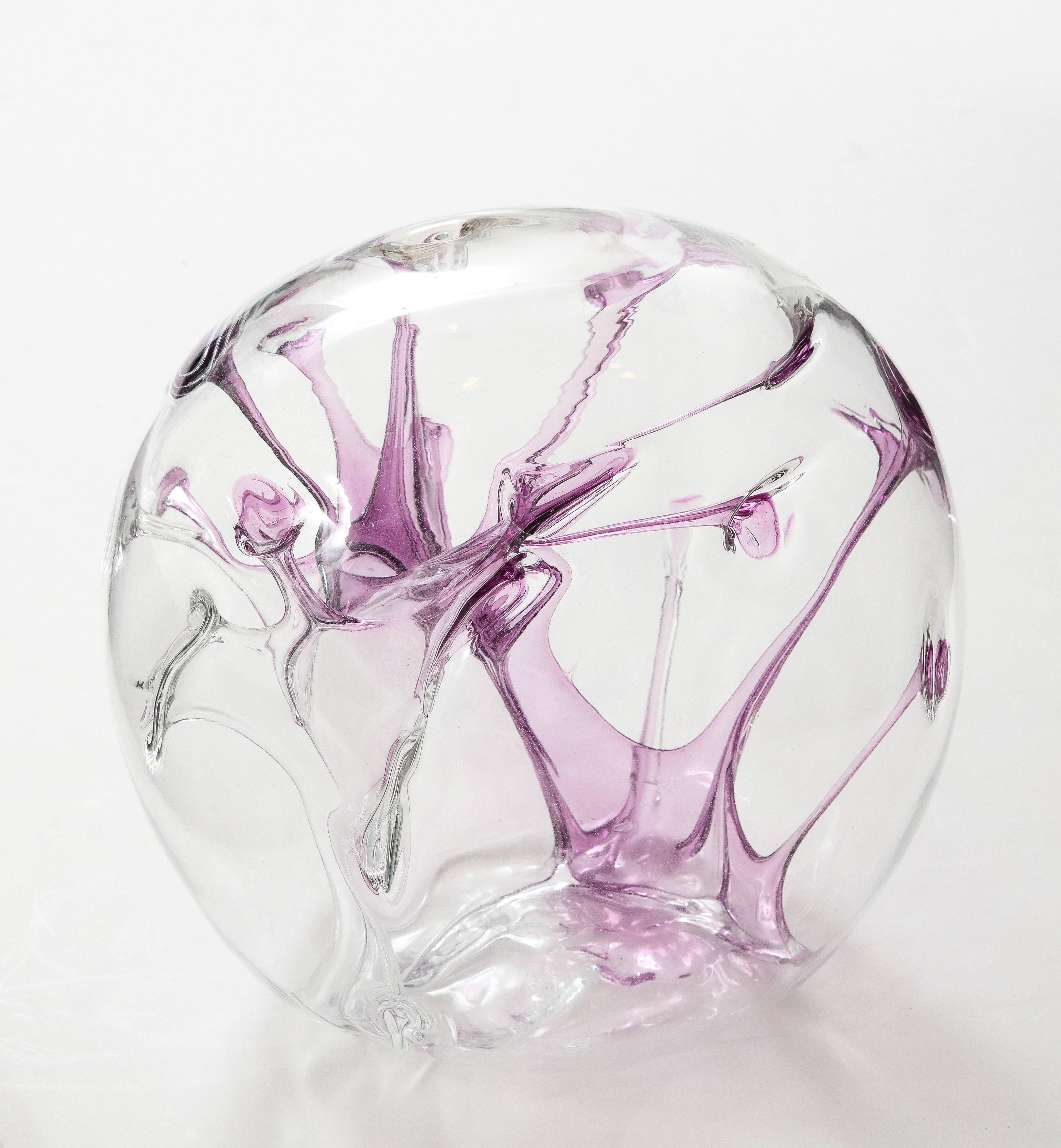 Sculpture orbe contemporaine en verre soufflé à la bouche avec fils de violette internes.
Signé Peter Bramhall.