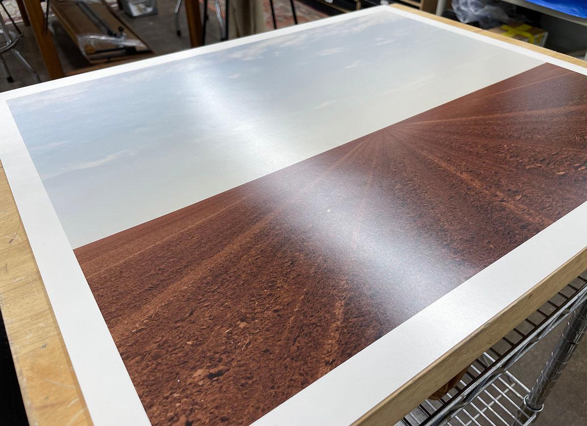 Levelland, TX by Peter Brown is a color photograph of a plowed dirt field, stretching out into the horizon to a dusty blue sky.

C-Print
18 x 22 in.
Ed. 11/25
Title, signature, date and edition written in black ink on print verso

Peter Brown has