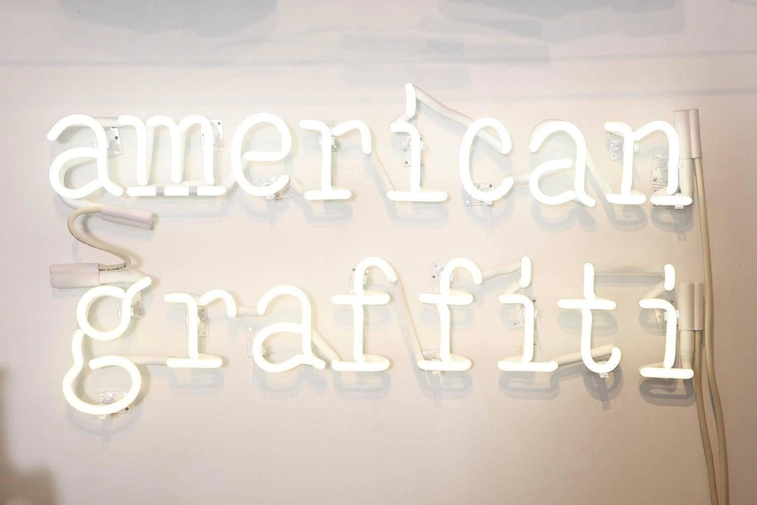 Contemporary New York artist Peter Buchman's American Graffiti Neon is in white for a reason. It's clean, clear, not cluttered, not everywhere and not obnoxious. The phrase is about his continued introspection of words and writing as well as our