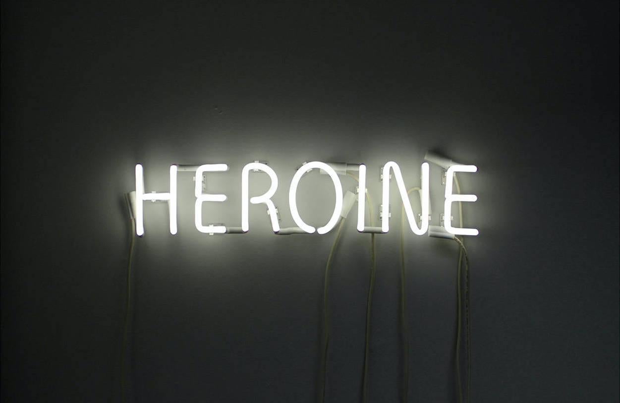 Contemporary New York artist Peter Buchman's Heroine White Neon is a provocative piece that blinks 3 different words randomly: Heroine - Hero - Heroin. The concept for this piece came from his love of words, storytelling, and movies. He is