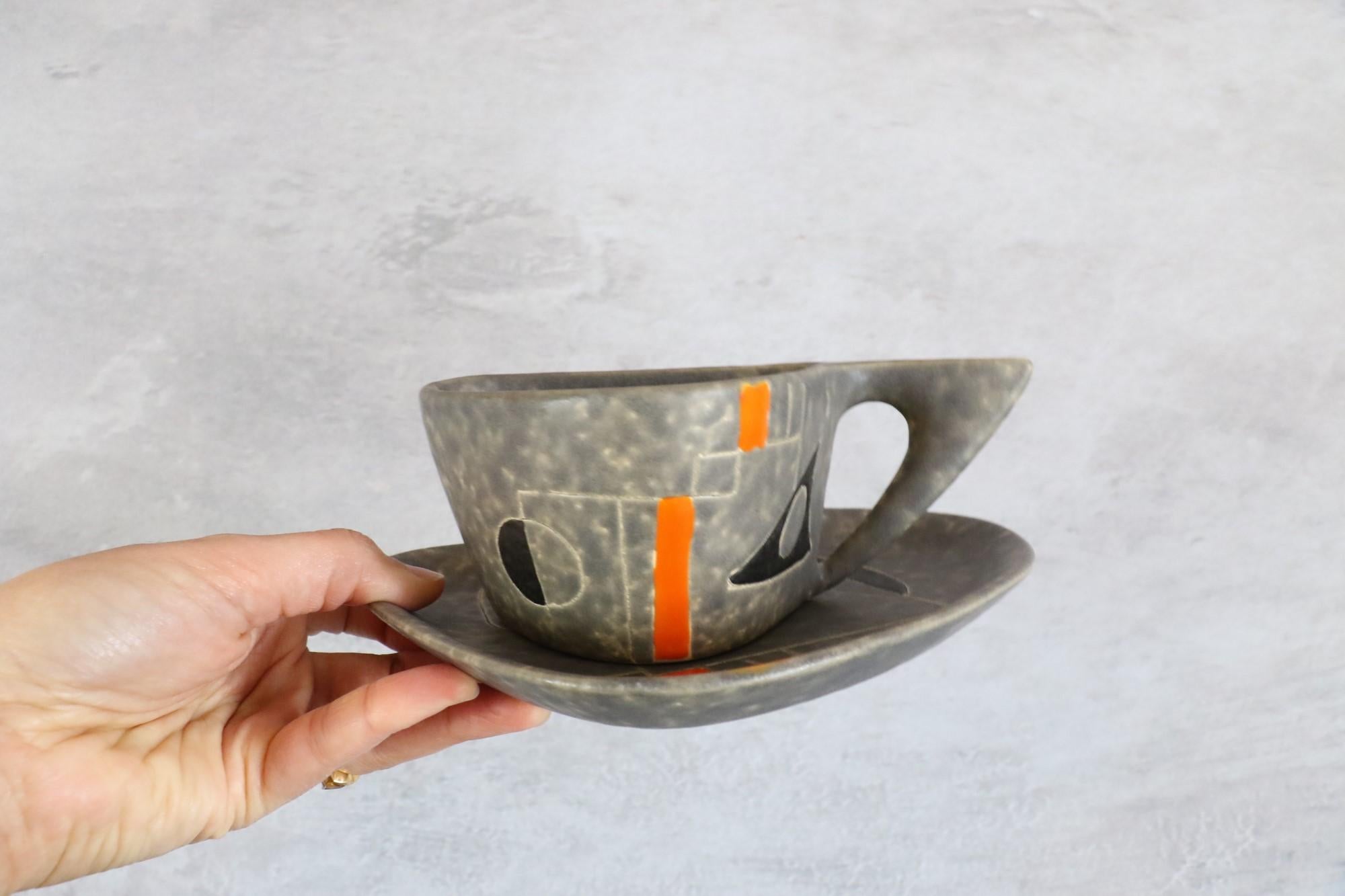 Peter & Denise Orlando, Mid-Century Modern ceramic tea set 1960s, Era Capron

Free form Ceramic cups and under cups by Peter and Denise Orlando, France 1960s.
Glazed in grey with abstract and geometric decoration engraved and over-glazed in