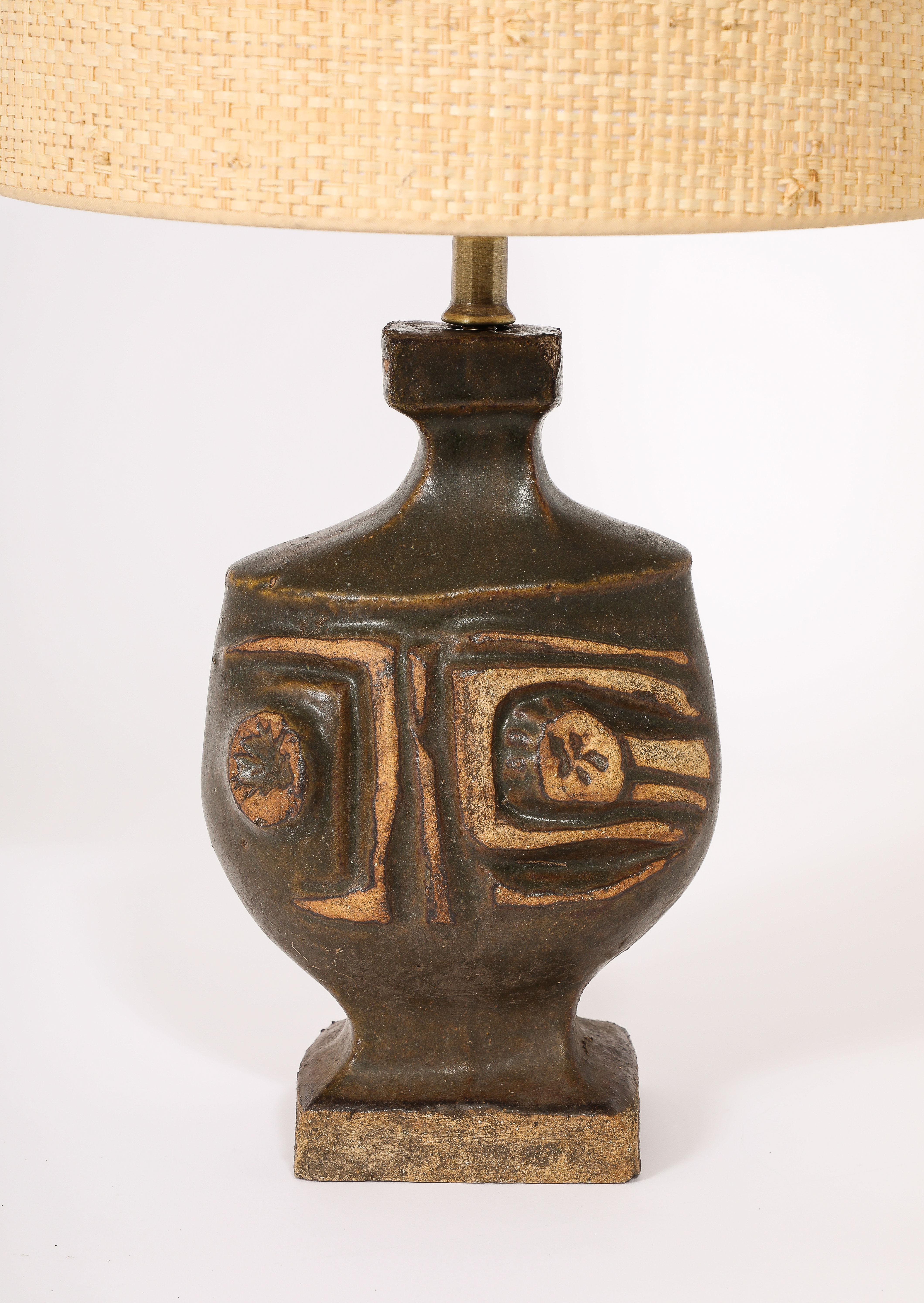 Wonderful brutalist table lamp in green ceramic by Peter Ellery, the decor is a deep relief abstract motif that looks like a face.

Base size only 13x6x3.
