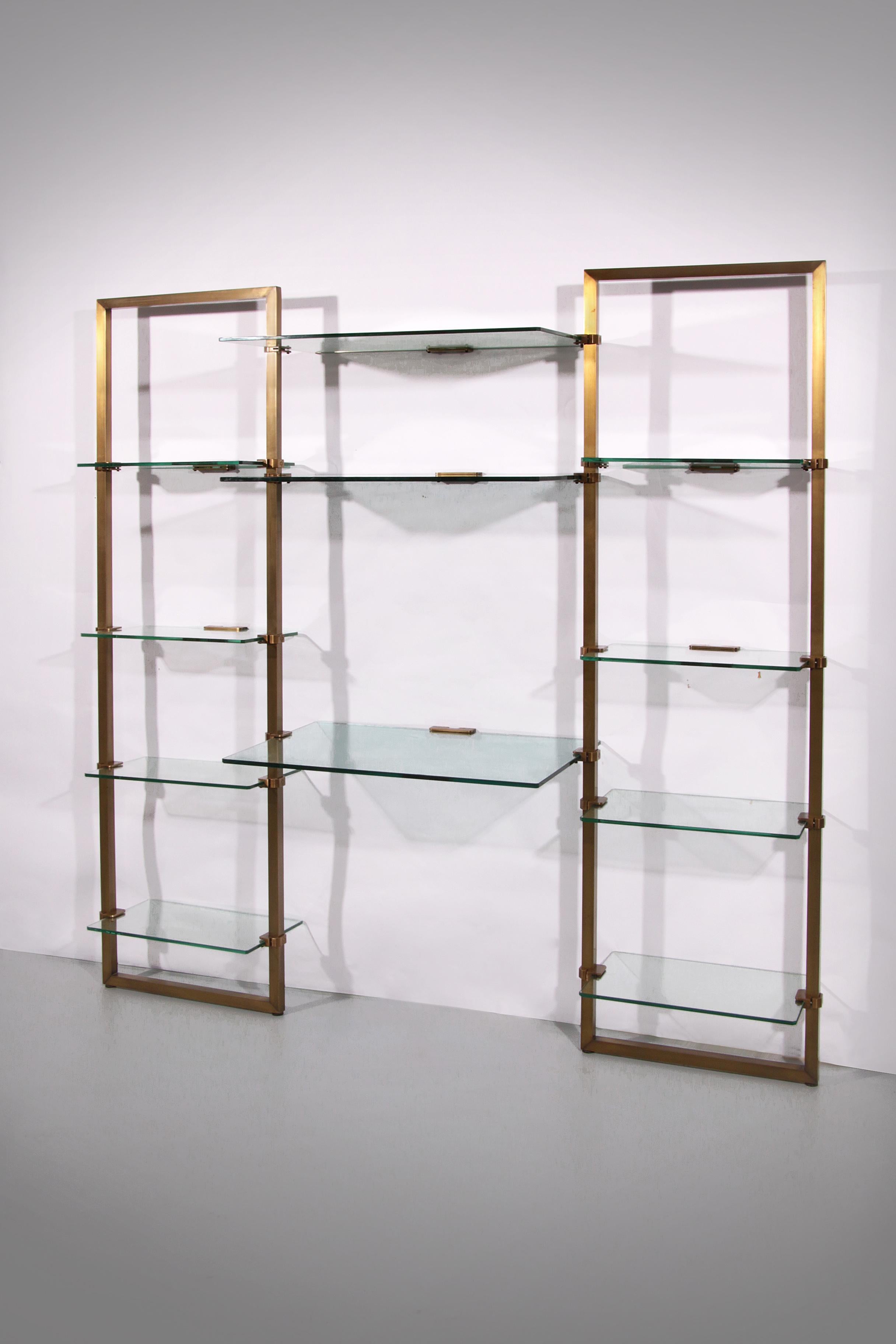 

This exclusive glass wall cabinet, designed by Peter Ghyczy in the 1970s, showcases a pioneering clamping system that has become the designer’s signature. The thick glass shelves are supported by sand-cast brass clamps attached to a fluid,
