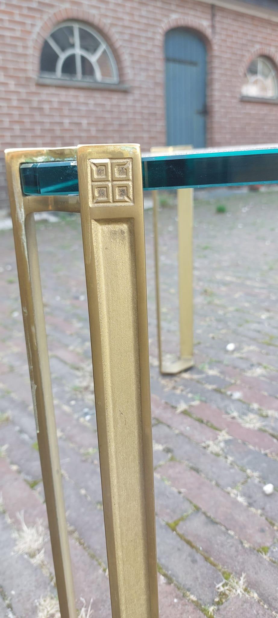 Mesa de centro cuadrada de cristal con patas de bronce fundido, diseño de Peter Ghyczy, década de 1970, Alemania.

La gruesa tapa de cristal se apoya en las esquinas sobre las pesadas patas de bronce, por lo que parece flotar.
Tablero de cristal