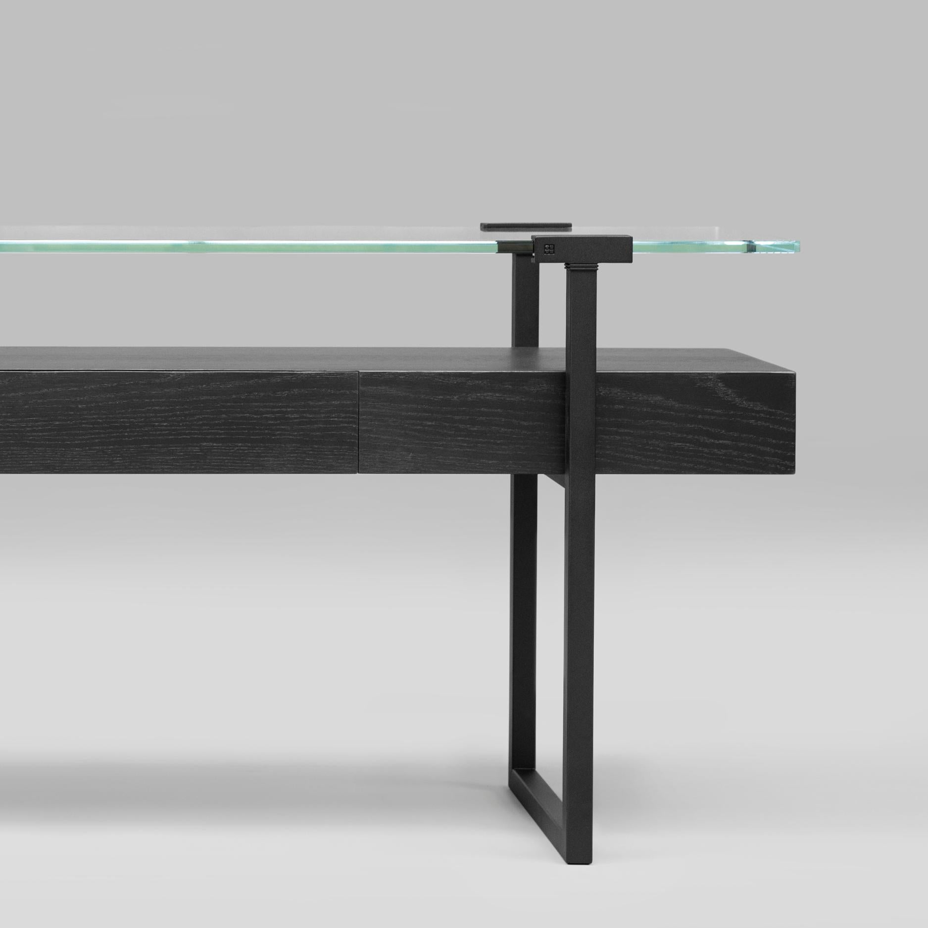 Console table designed by Peter Ghyczy in 2009.
Manufactured by Ghyczy (Netherlands)

The twin frames are constructed of 3 × 3 square tubes and secured to the tabletop by cast metal details. Special feature is a solid wooden drawer. The strong